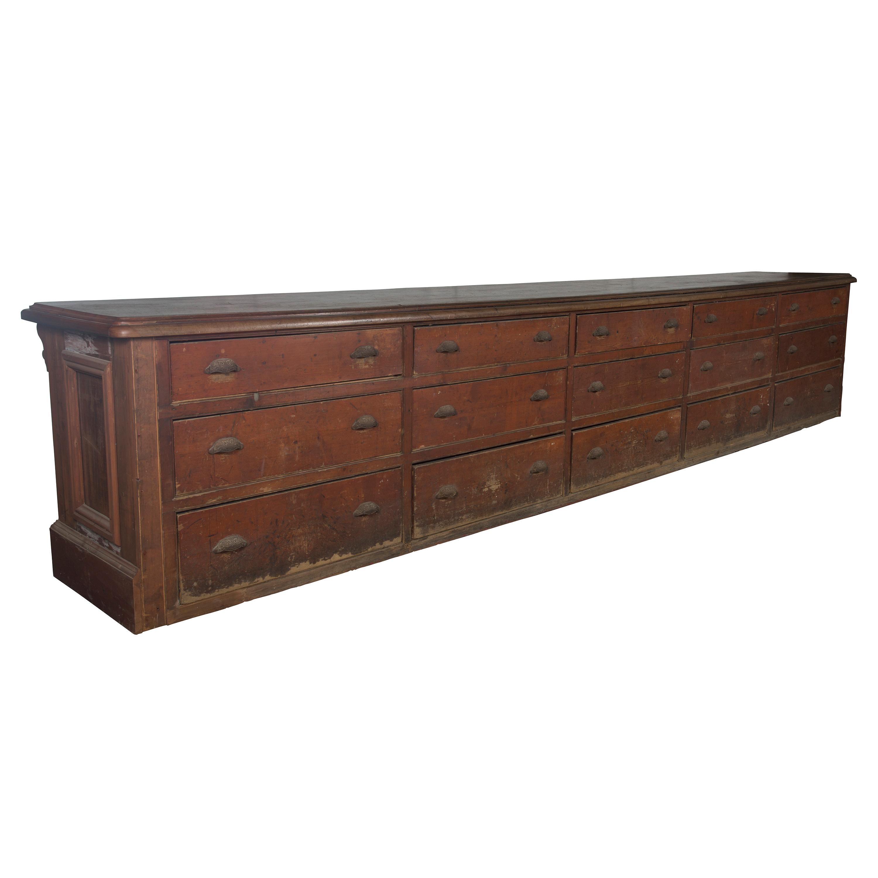 A monumental, fifteen foot long, free standing 19th century, original painted pine shop counter. A single plank mahogany top and fifteen large drawers. This counter originated from a haberdashery in Liverpool.

In very good condition, with some
