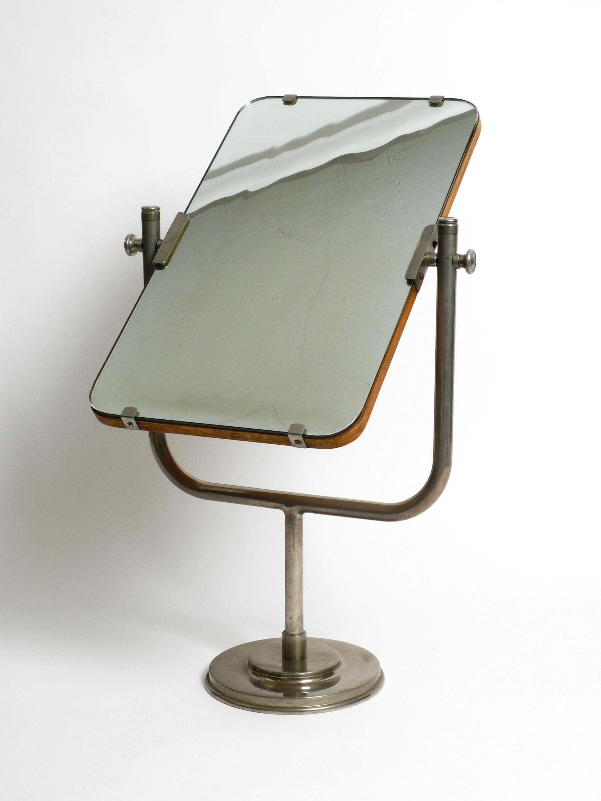 Fantastically beautiful huge 1930s swiveling table mirror.
Great pre-war German design.
The mirror can be moved freely and fixed with the screws.
The frame is made entirely of nickel-plated metal. Heavy foot for stable standing.
The 7 mm thick