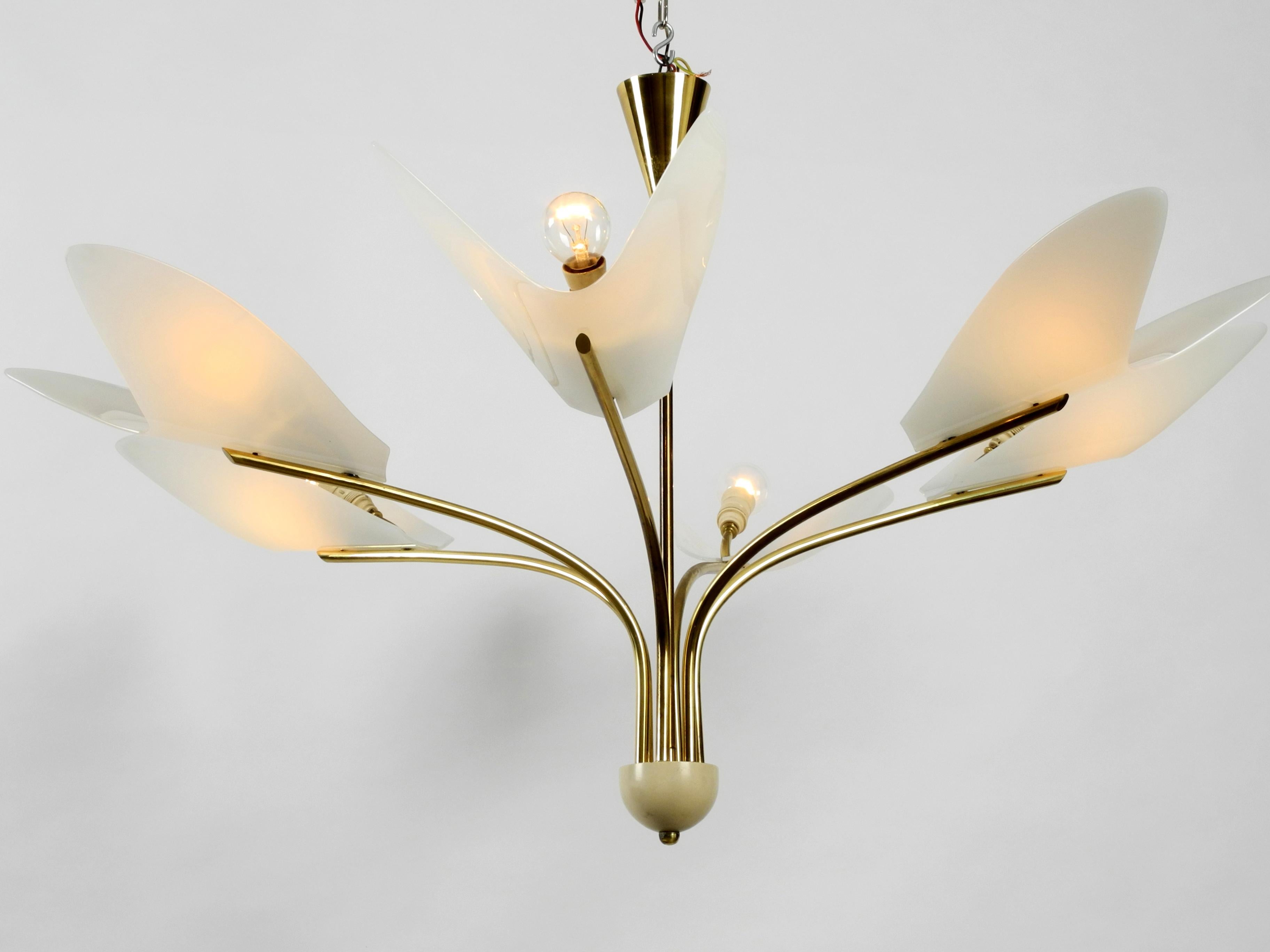Gorgeous giant Mid-Century Modern brass chandelier with six arms made of brass and big Plexiglas shades.
Extraordinary rare design with wing-like white lampshades.
Six original metal E14 sockets for max. 40W each.
In very good condition. Suitable