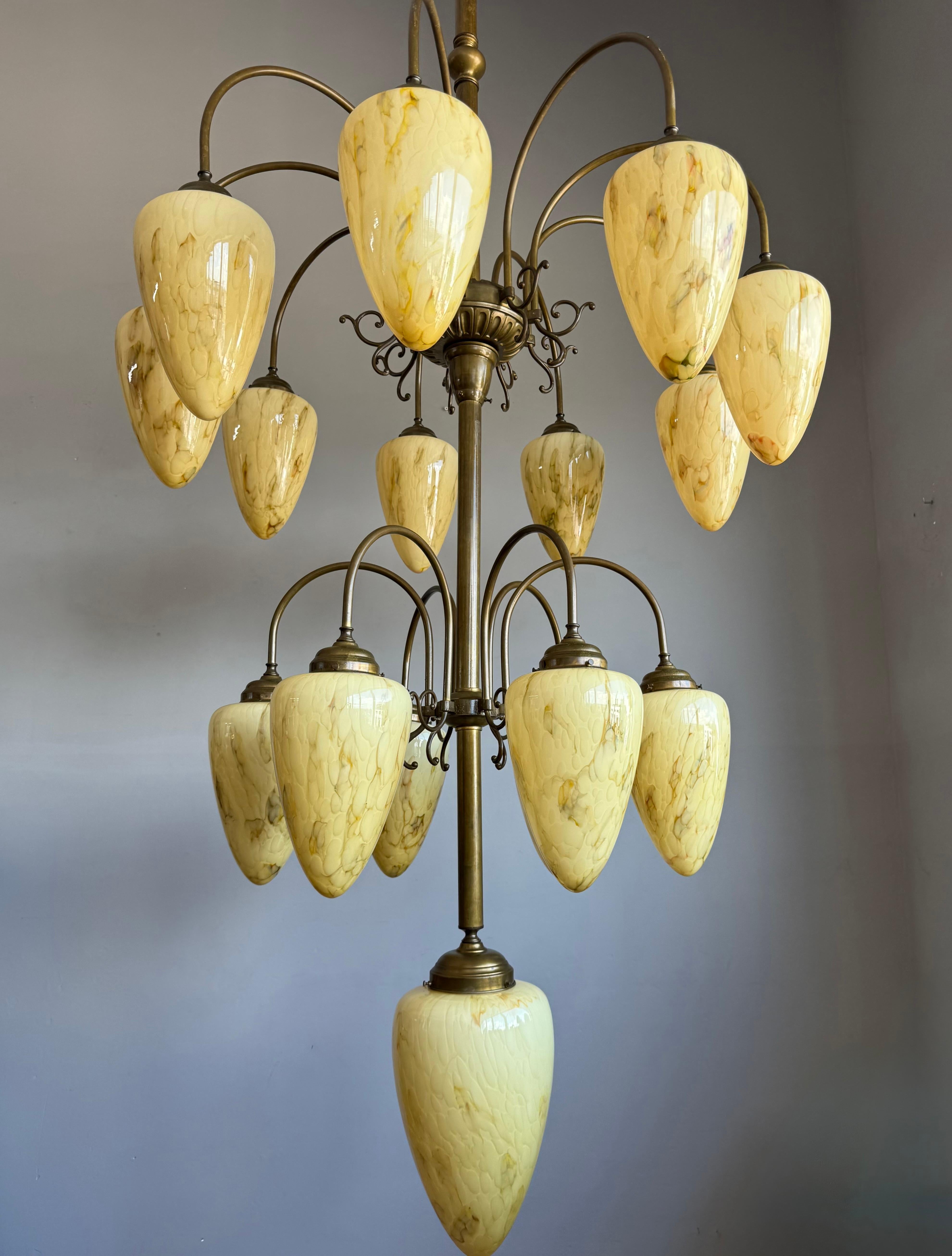 Énorme lustre en laiton et verre soufflé du milieu du siècle dernier, style Art déco, années 1950.

Un lustre monumental rare et époustouflant des années 1950, fabriqué à la main avec une élégance intemporelle et une influence Art déco audacieuse.