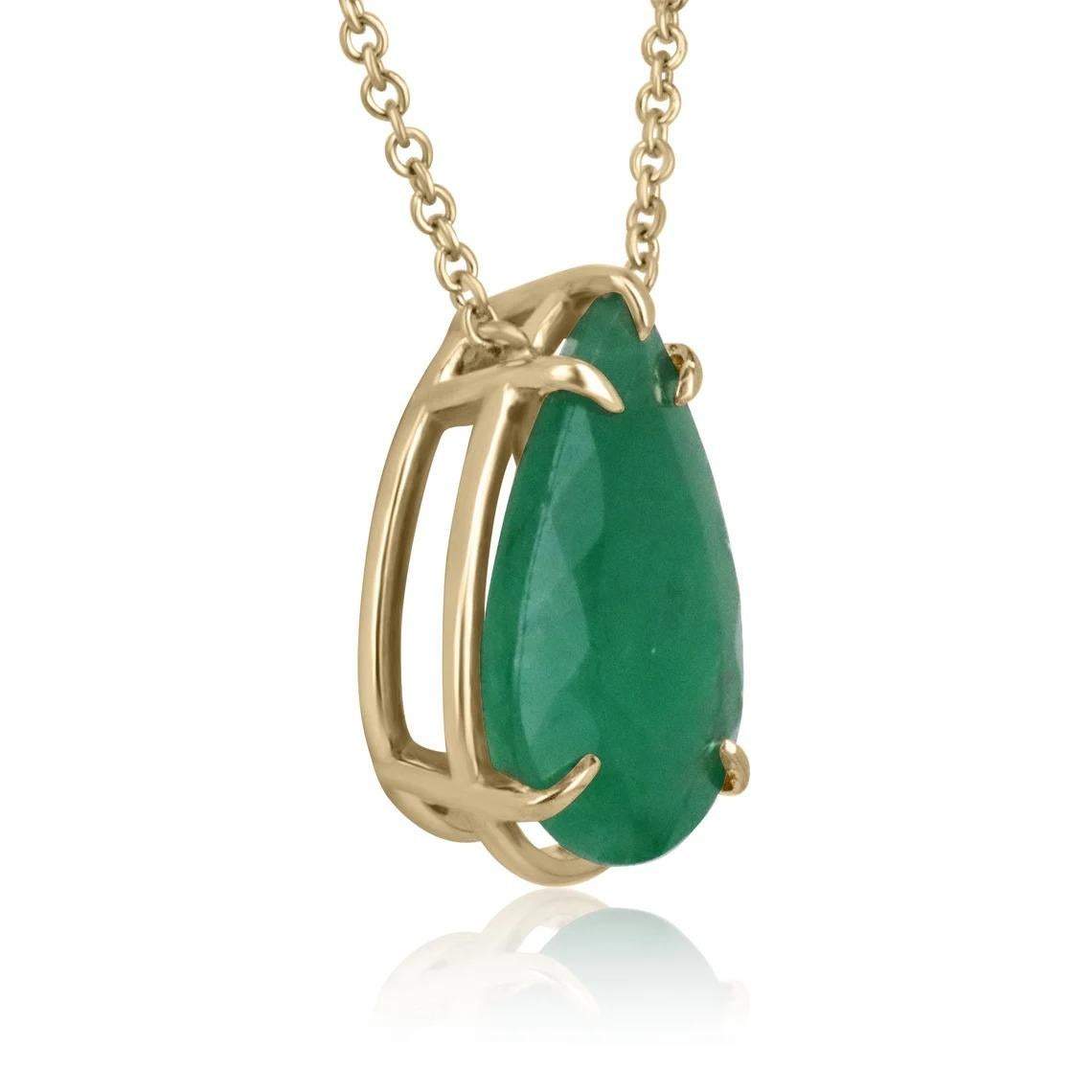 Displayed is a classic Brazillian emerald solitaire necklace set in 14K yellow gold. This gorgeous solitaire ring carries a full 9.30-carat emerald in a five-prong setting. Fully faceted, this gemstone showcases excellent shine. The emerald has good