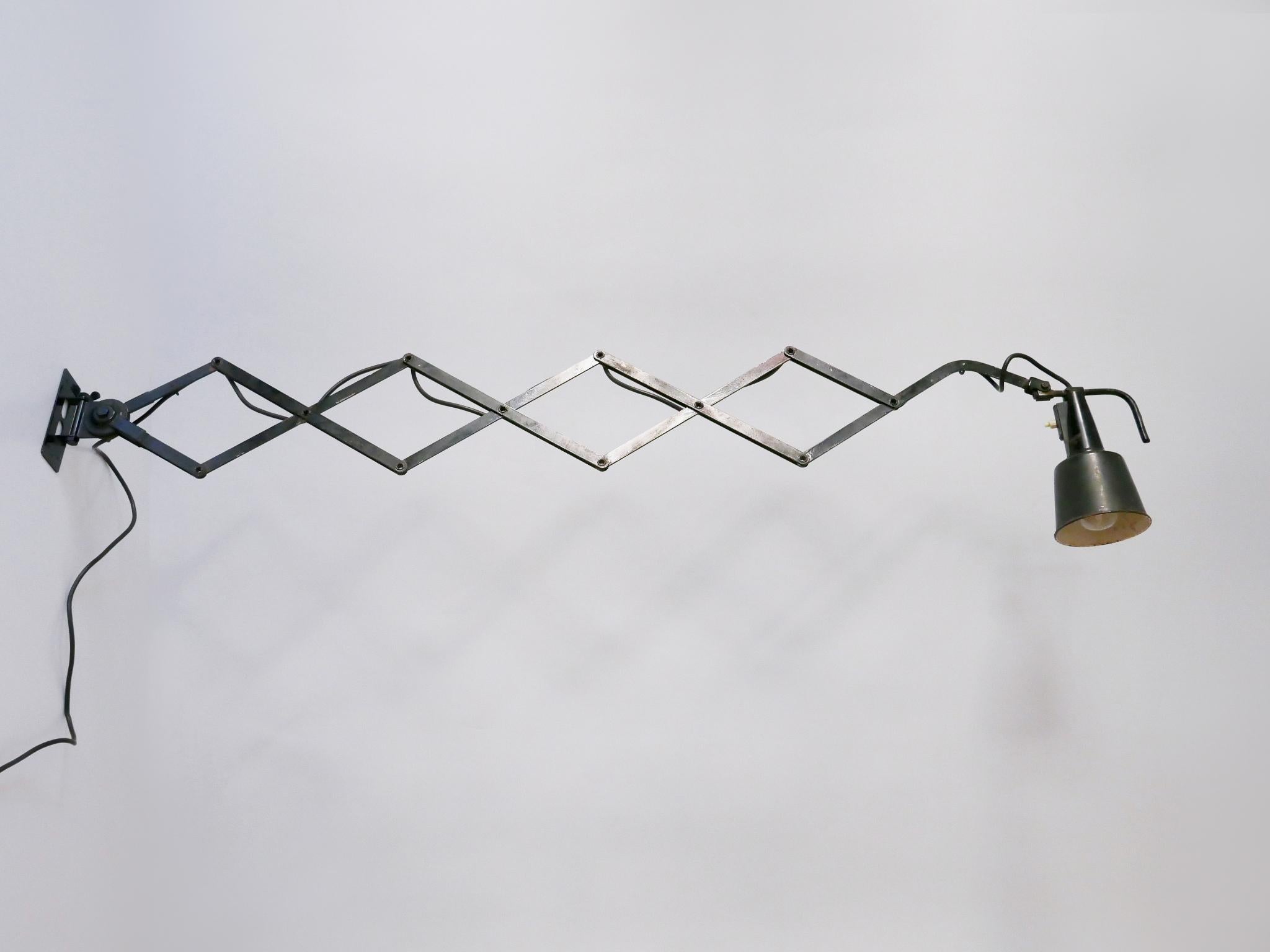 Huge, articulated Bauhaus scissor wall lamp. Adjustable and extendable arm. Lamp shade adjustable in every position. Extendable between 15.75 –  55.12 in. (40 – 140 cm). A real work shop or desk light. Designed by Wilhelm Bäder, Germany, 1930s.

The