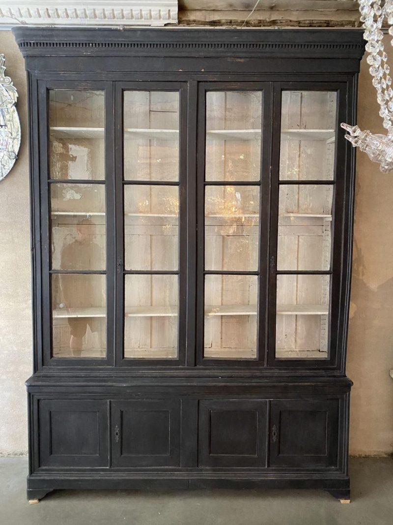 Impressively large and handsome antique display cabinet, in two parts. Originally a bookcase with a display section and lower part with painted quality wooden doors, as well as adjustable full width wooden shelves.

circa 1890s France, still with