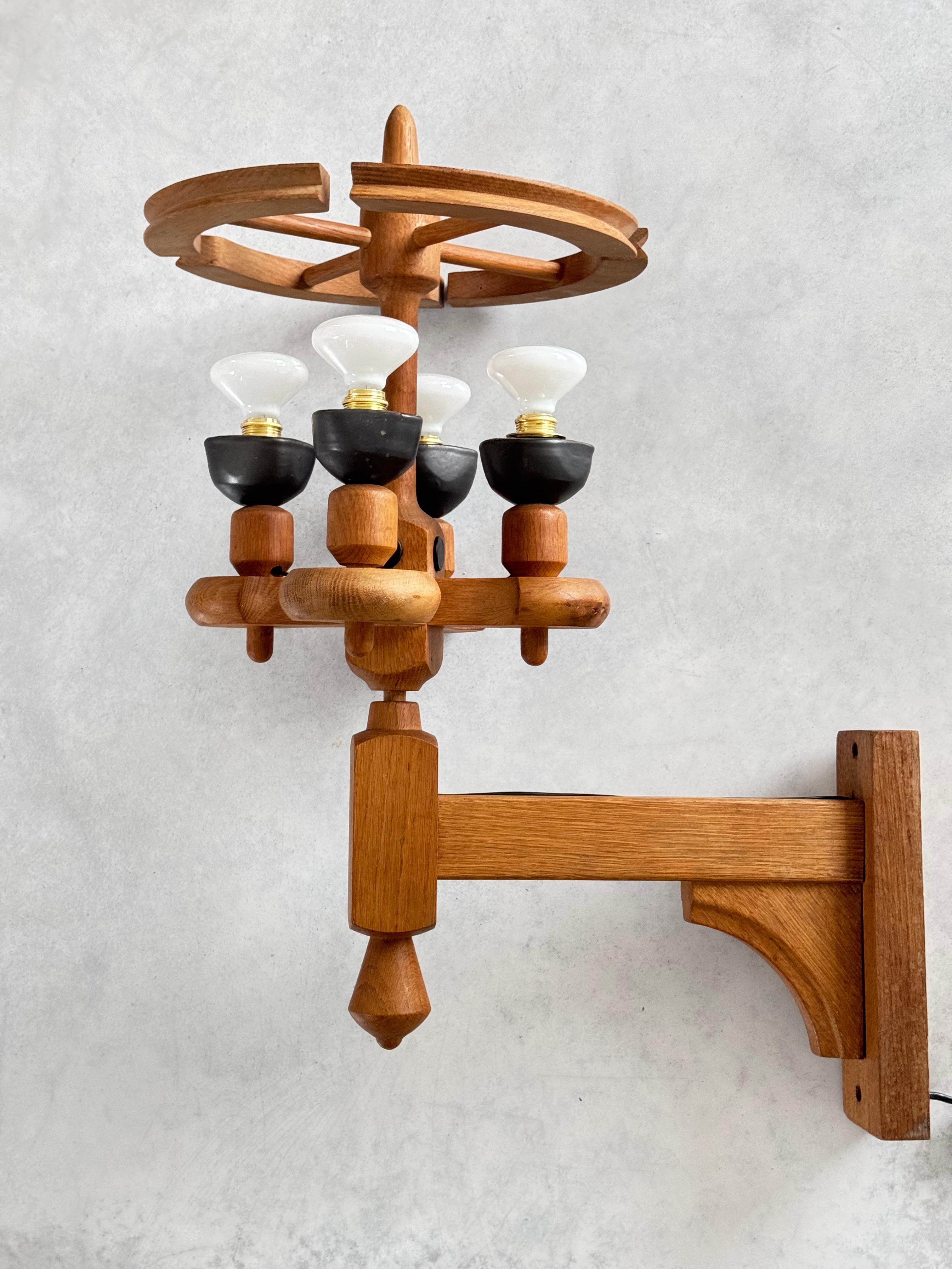 Descubre esta pieza rara y elegante: una lámpara de pared de roble macizo, diseñada en los años 60 por los célebres diseñadores franceses Robert Guillerme y Jacques Chambron. Esta lámpara, que encarna a la perfección la estética modernista combinada
