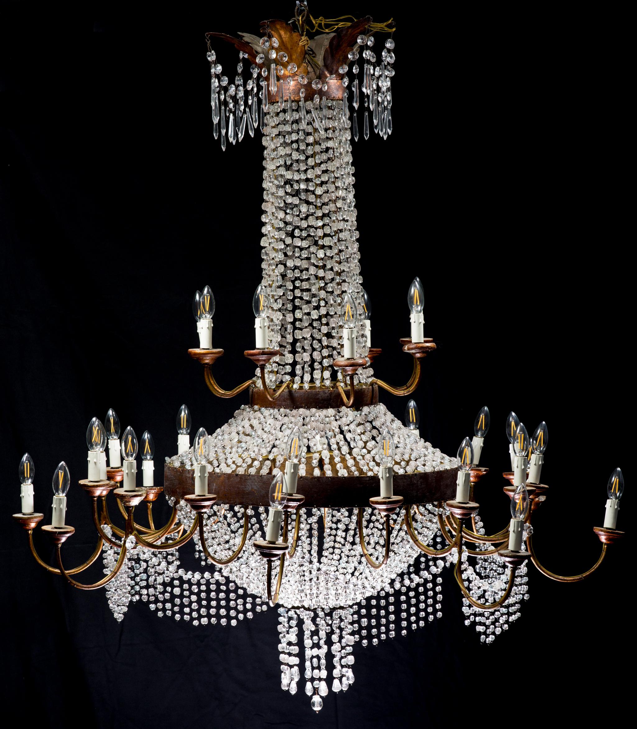 A very impressive Baroque-style chandelier with crystals and 34 lightbulbs from Italy made at the beginning of the 20th century. This huge chandelier consists of three levels which are divided by iron rings. The dressing of the chandelier is