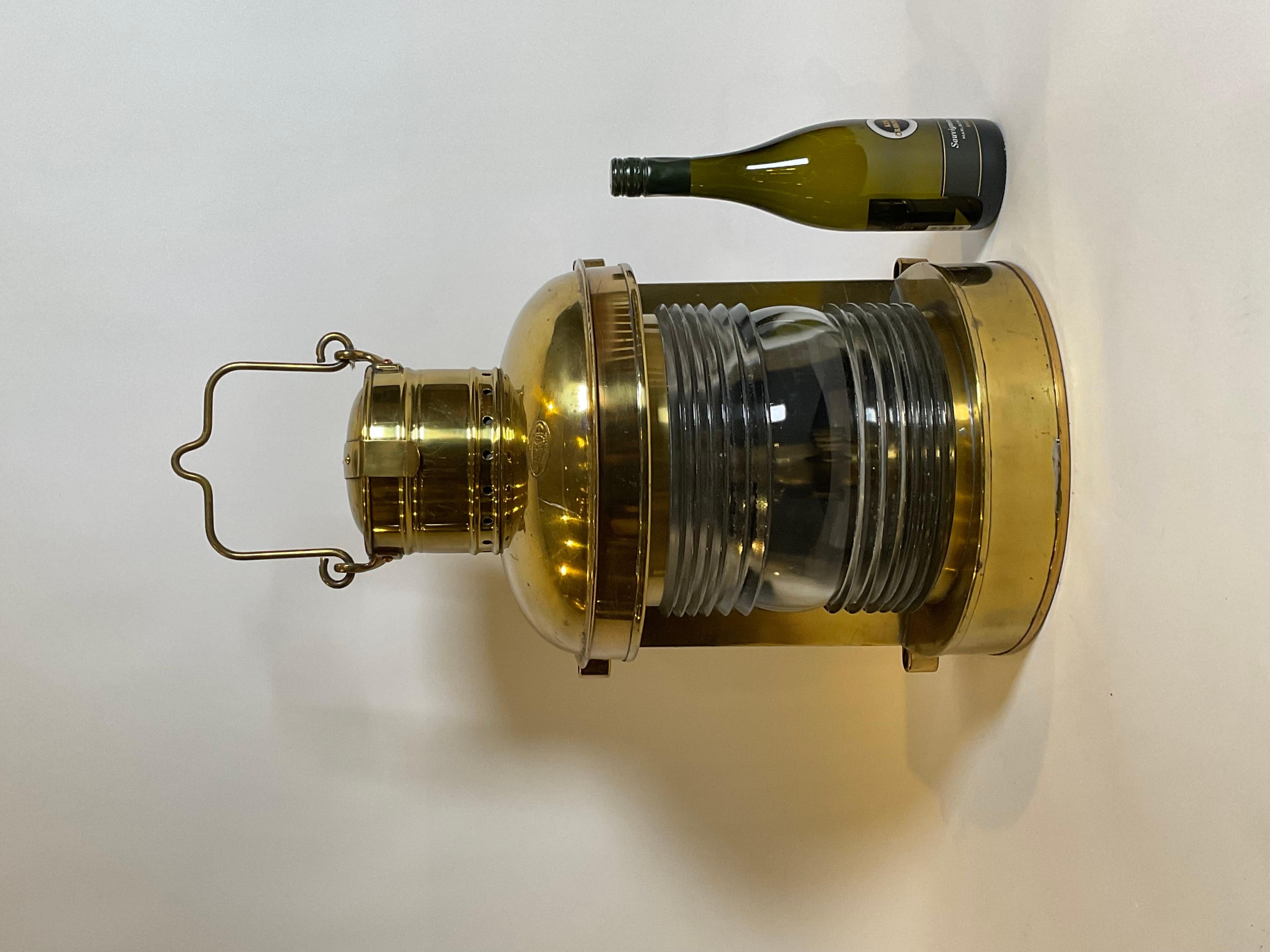 Solid brass ships masthead lantern. American made by Perkins Marine Lamp Corporation of Brooklyn, New York. Fitted with a glass fresnel lens. Old lacquered finish. With original burner and tank.

Weight: 22 lbs.
Overall Dimensions: 20