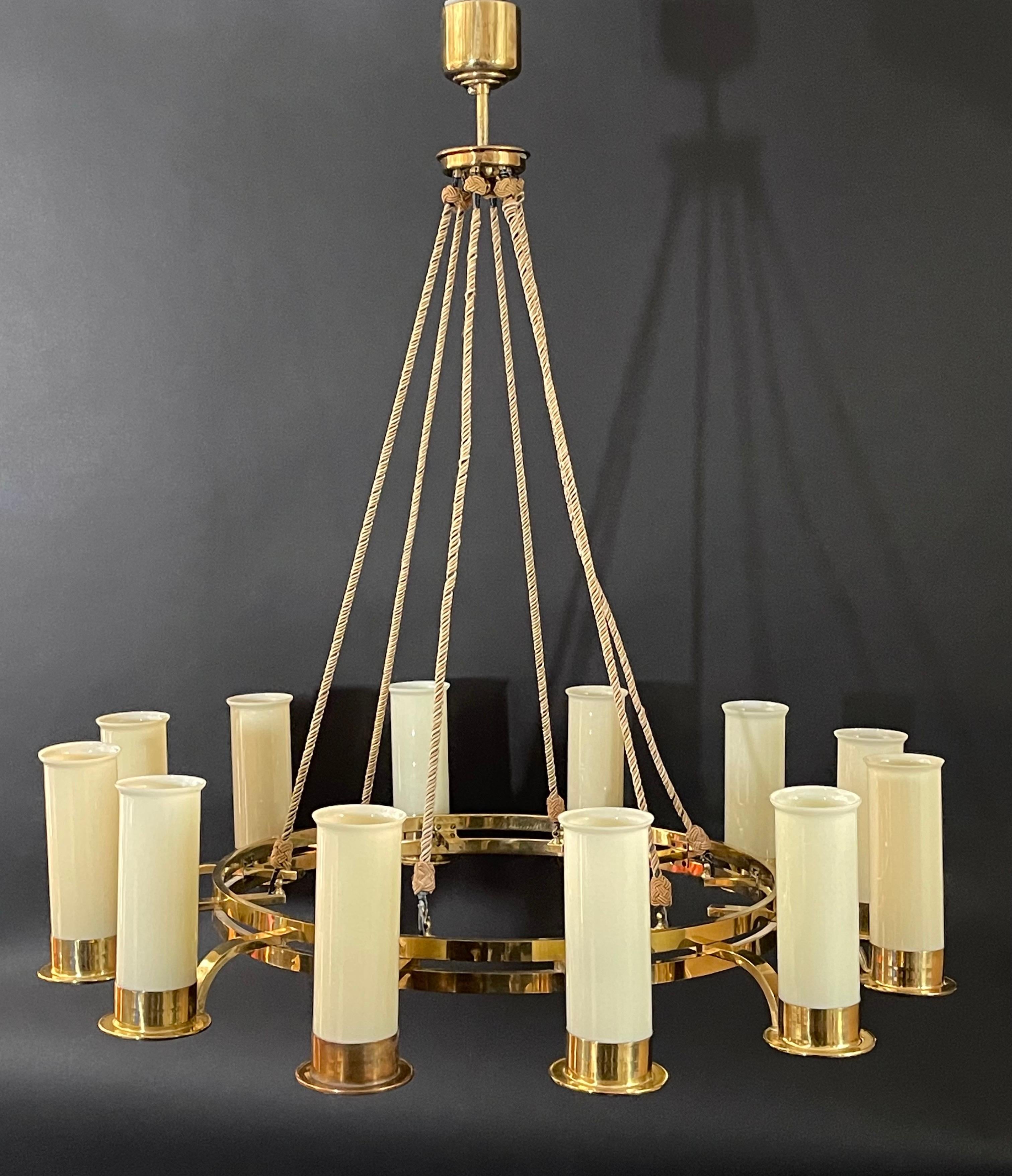 Huge Art Deco glass and opal brass chandelier, circa 1930s.
This beautiful chandelier is made of round polished brass frame and opal glass tubes.
Socket: 12 x Edison (e27) for standard screw bulbs.

The condition is excellent.

