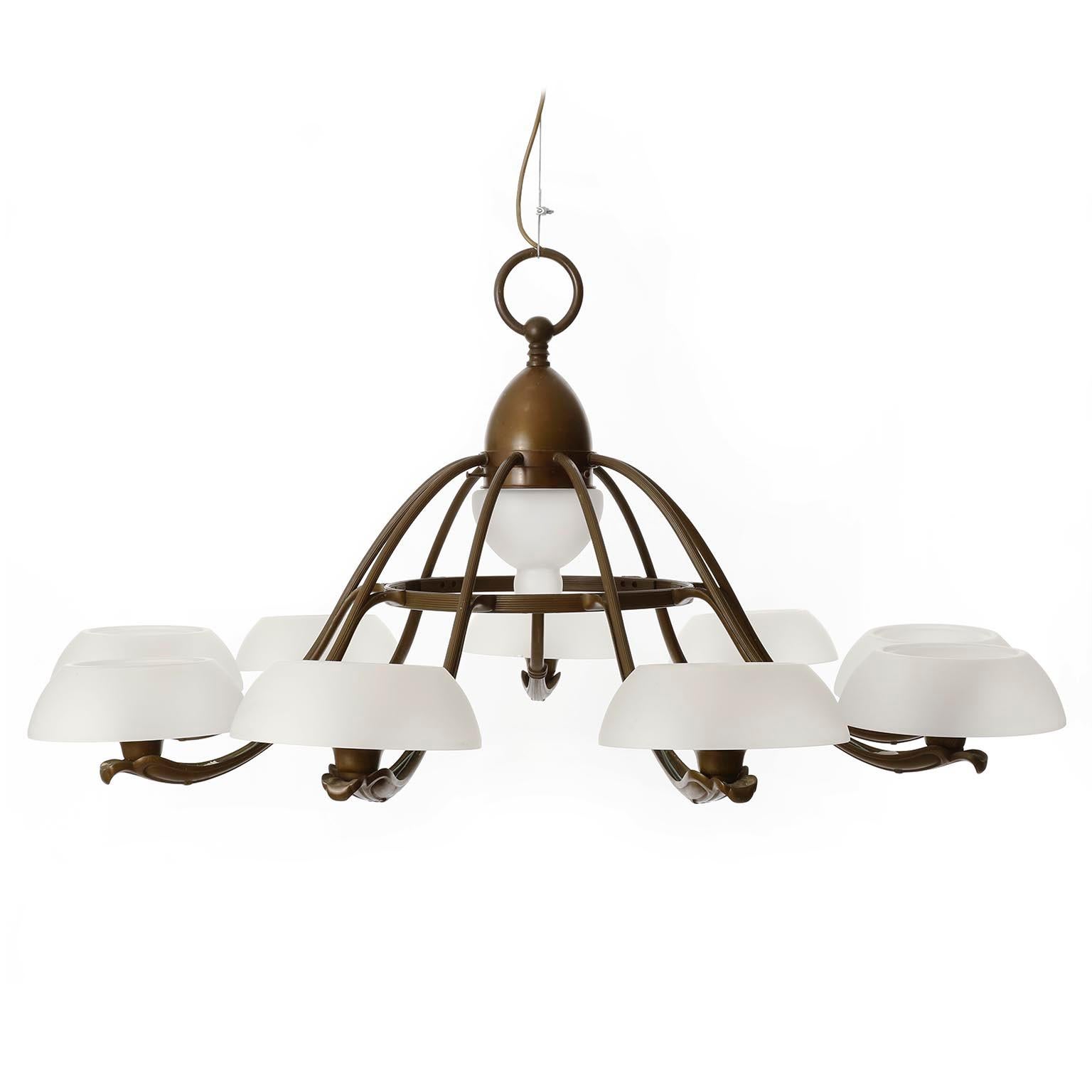 An extra large organic shaped 9-arm chandelier manufactured in Sweden, circa 1930.
It is made of a patinated brass or bronze frame with opaline glass lamp shades.
Each of the nine arms holds a socket for a medium or standard screw base bulb. There