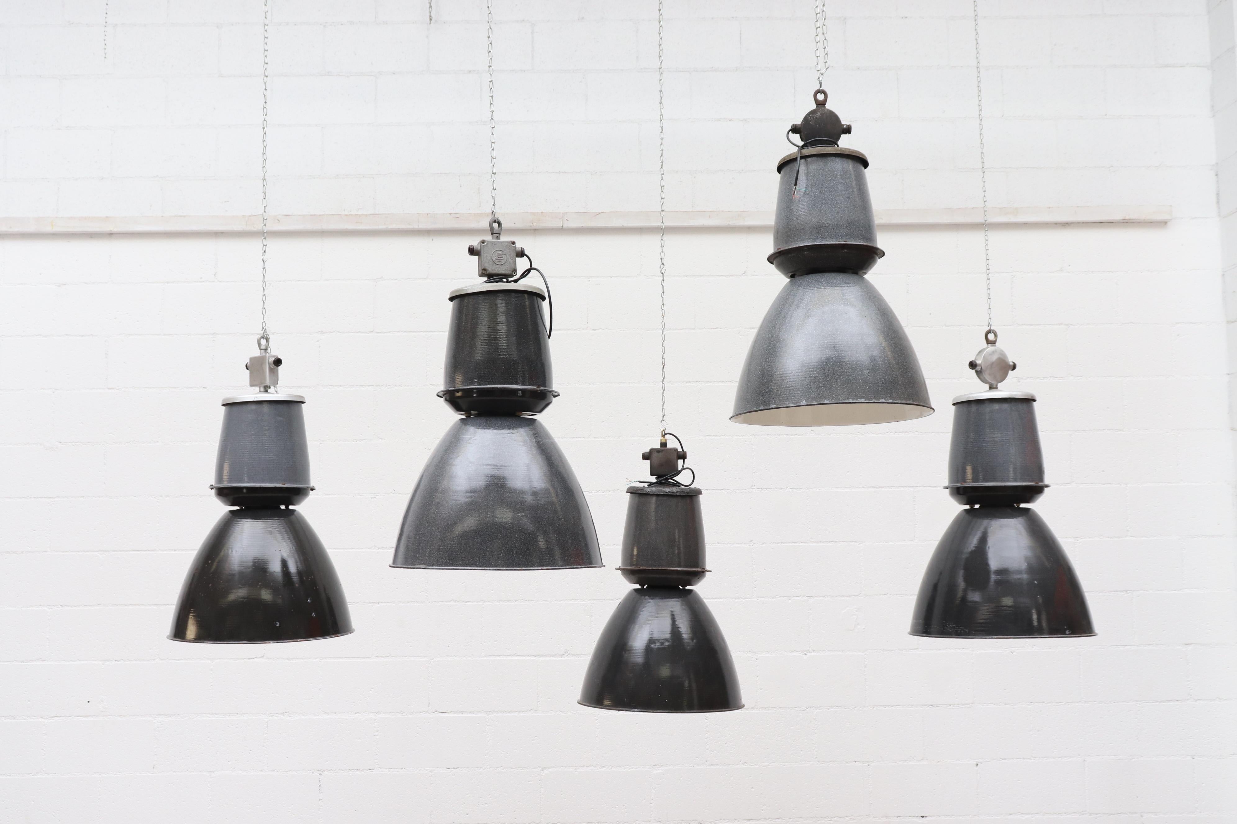 Gorgeous industrial charcoal enameled factory ceiling lamps and white enameled interior. All in original condition with visible wear and minimal chipping consistent with their age and usage. Others available in varying color tones Listed Separately. 