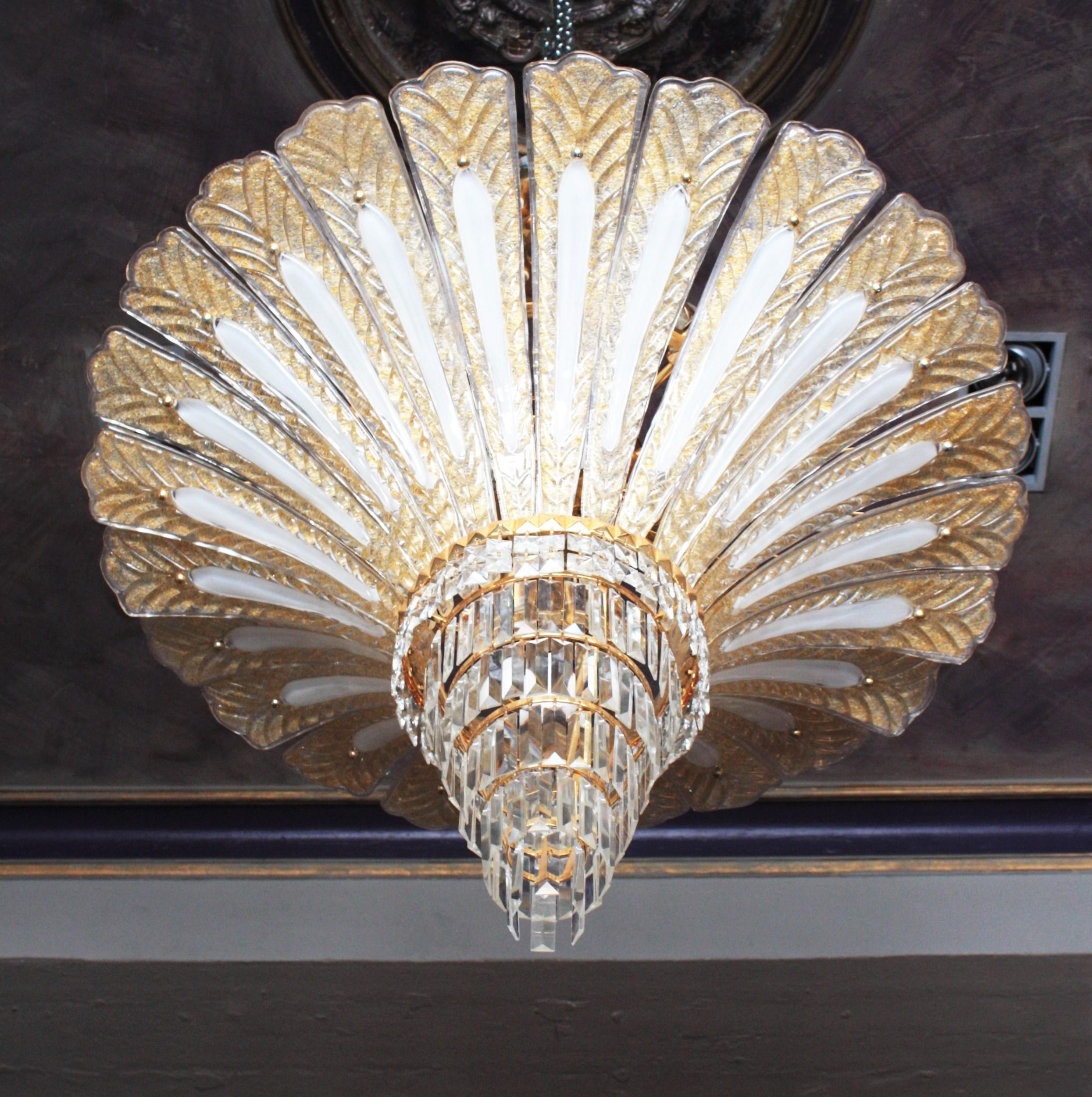 Outstanding and luxury palm tree chandelier in clear and amber Murano glass with gold leaf inclusions. Attributed to Barovier e Toso, Italy, 1990s.
This huge hand blown chandelier features a palm shaped design with 24 large leaves made of blown