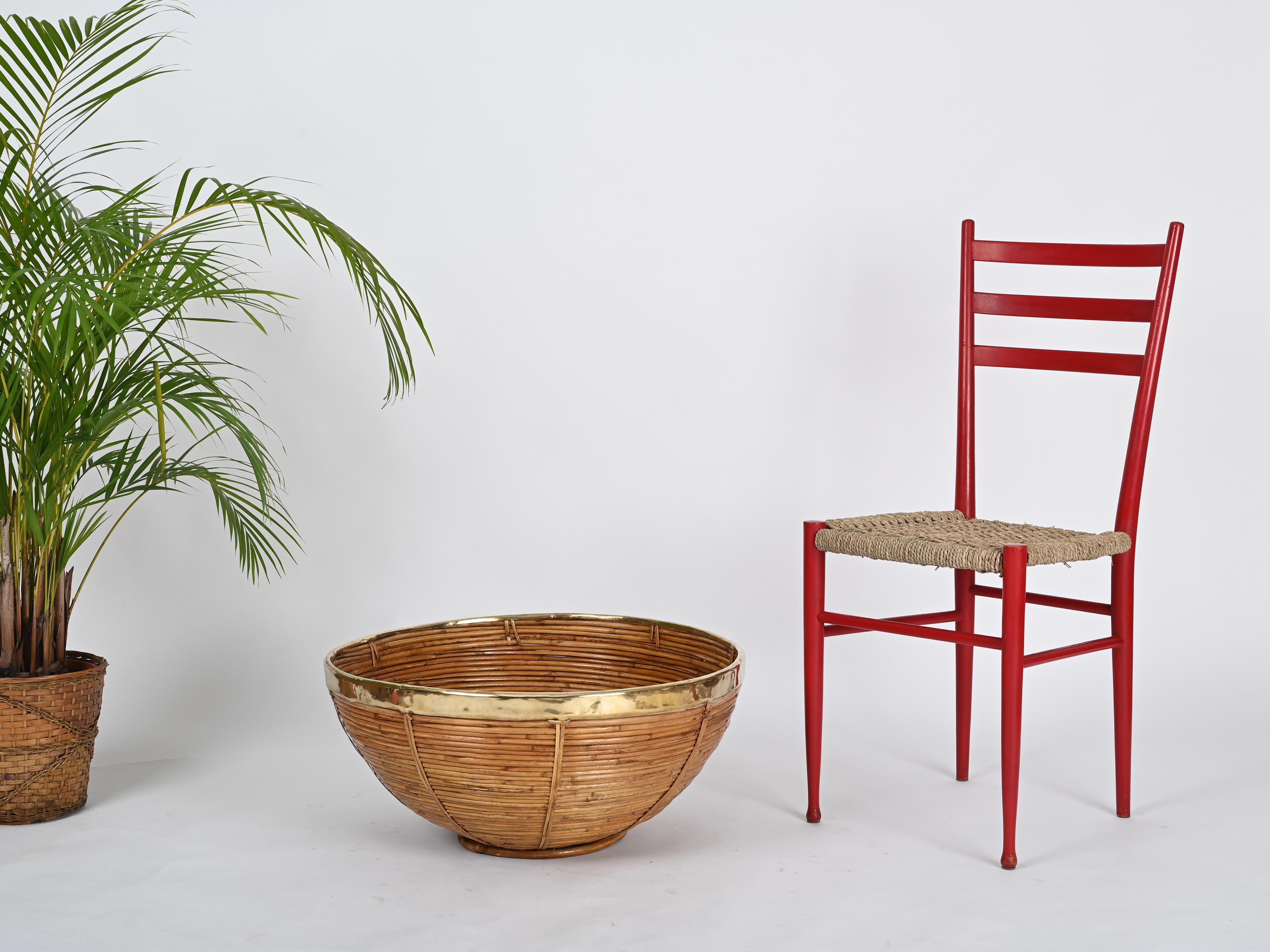 Magnifique très grand panier décoratif entièrement réalisé en rotin courbé, osier et laiton. Ce ravissant objet décoratif a été produit en Italie dans les années 1970 par Vivai del Sud.

Dans des conditions étonnantes et avec une merveilleuse