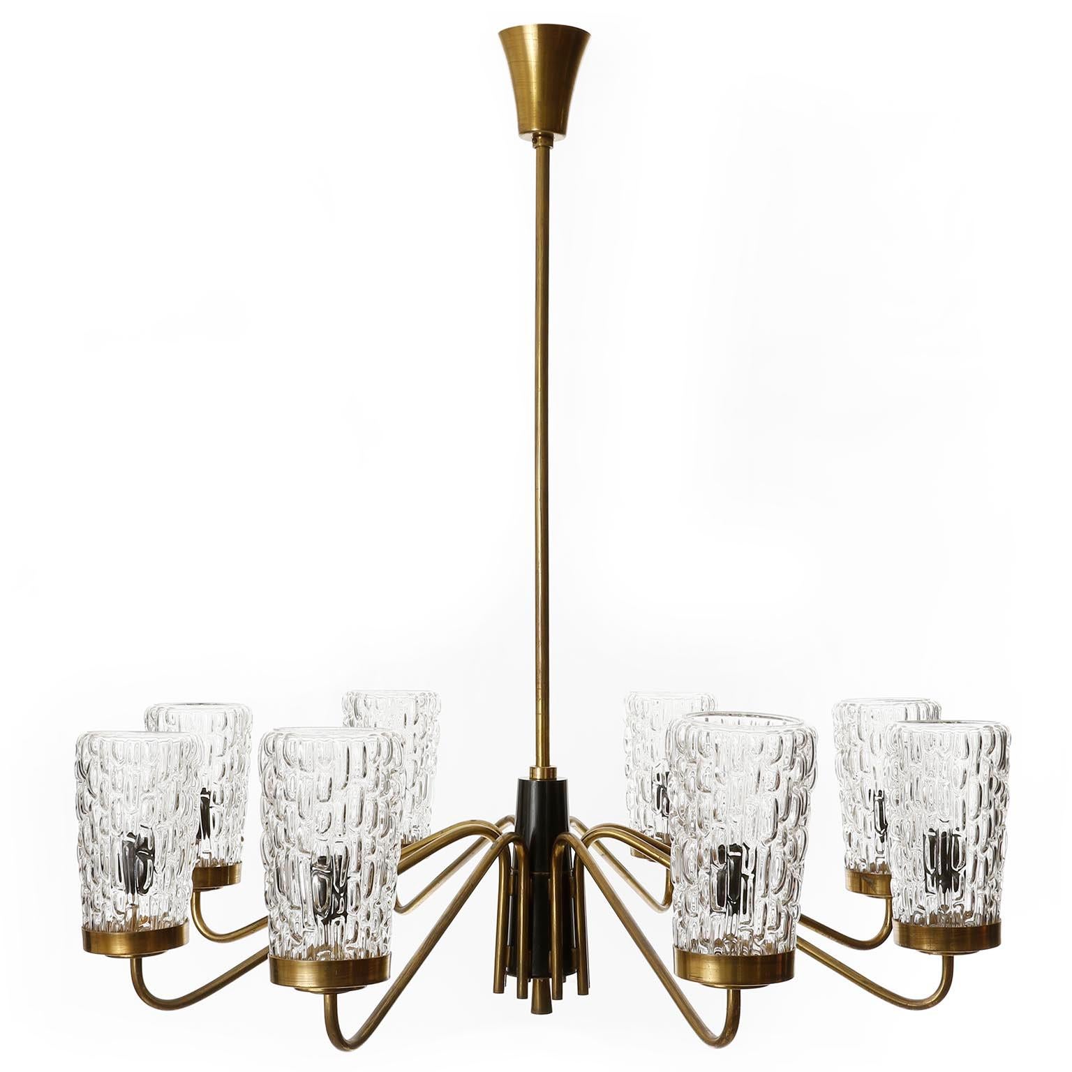 An extra large eight-arm chandelier by Rupert Nikoll, Vienna, manufacured in Mid-Century, circa 1960 (late 1950s or early 1960s). 
The fixture is made of a nice mixture of materials: large textured clear glass lamp shades, patinated brass and black