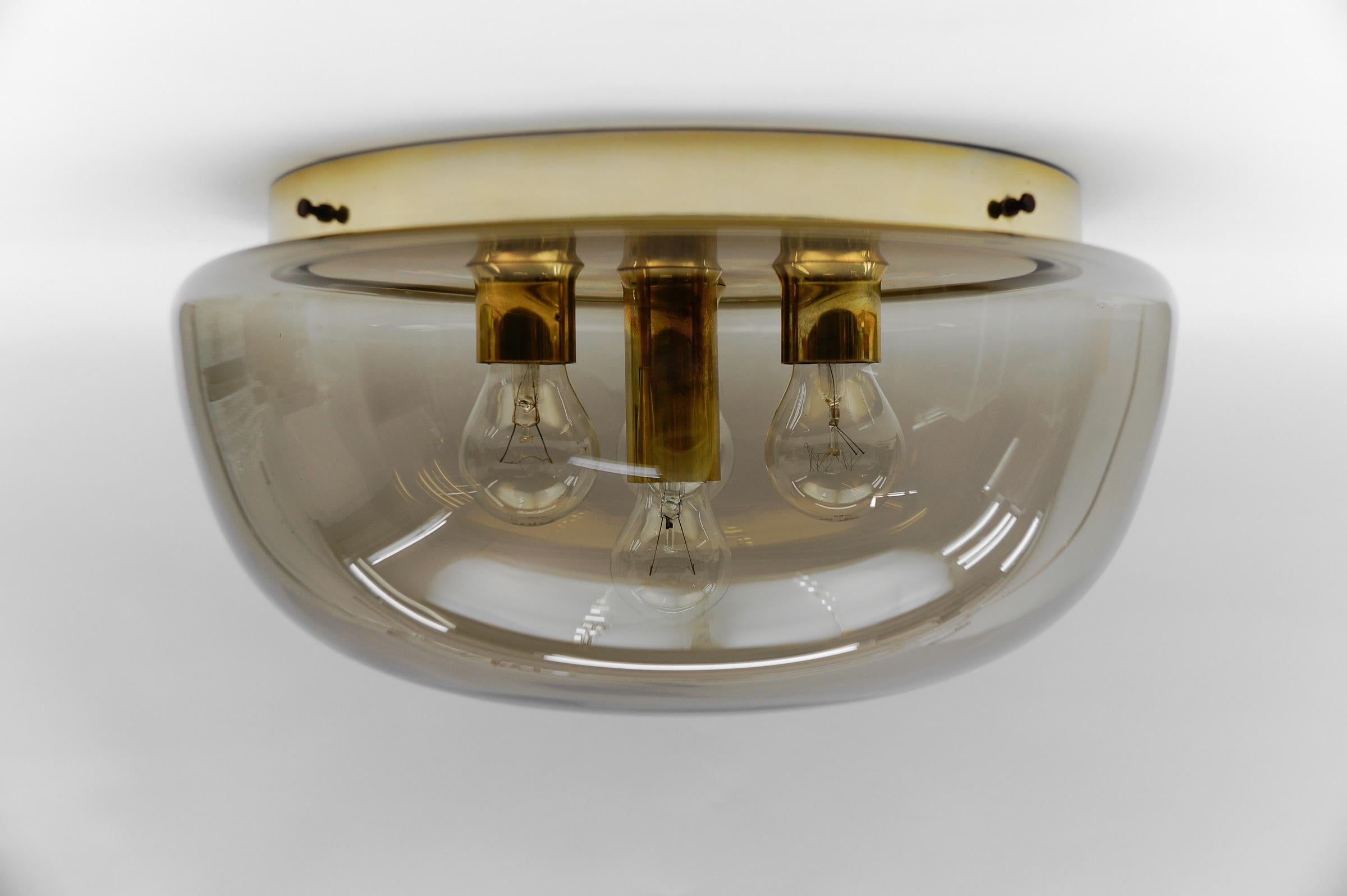 Huge Brass and Smoked Glass Flush Mount by Limburg, Germany 1960s

The fixture need 4x E14 standard bulb with 60W max.

Light bulbs are not included. 
It is possible to install this fixture in all countries (US, Australia, Asia, UK, Europe,..)
