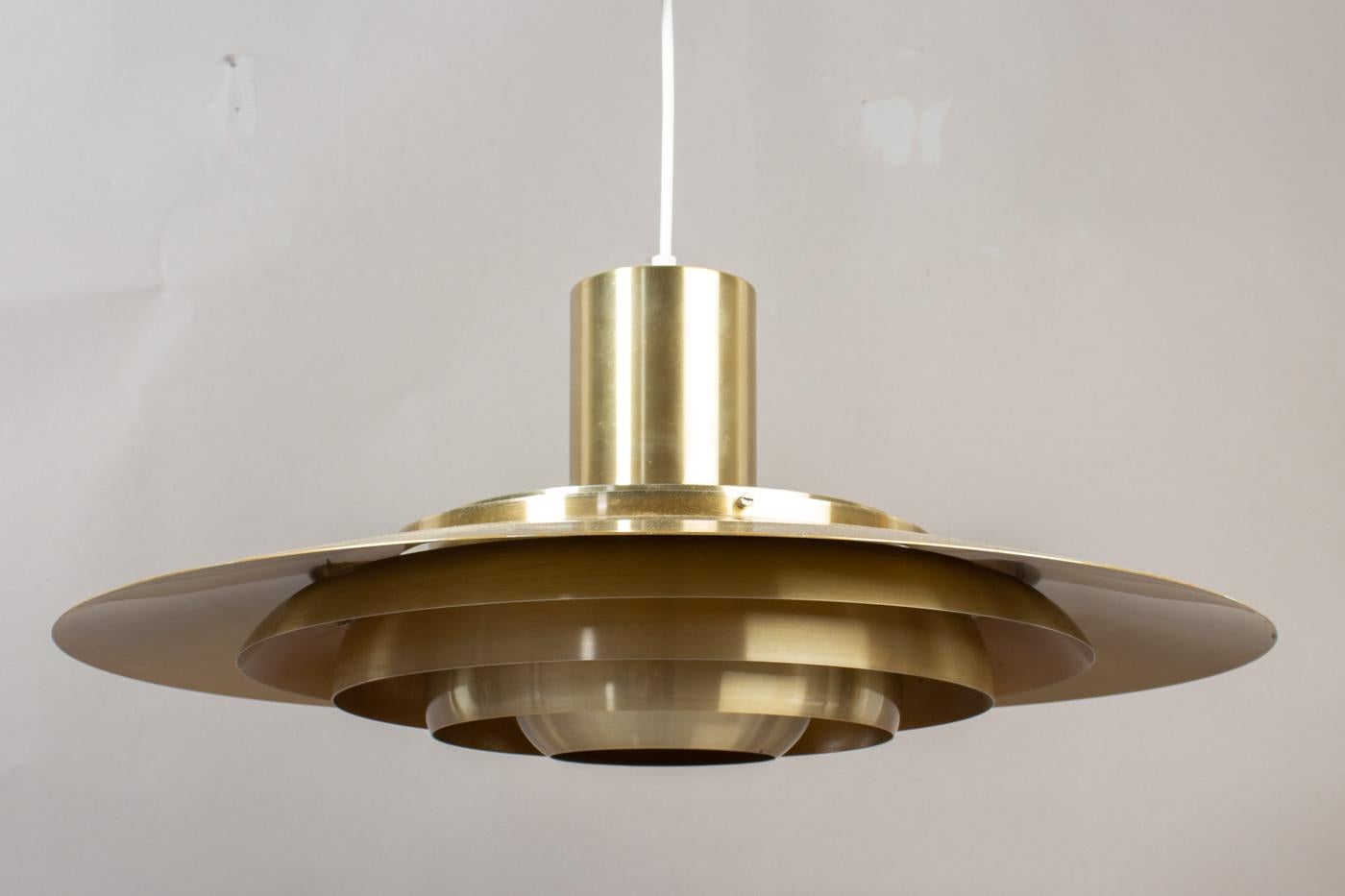 Aluminium pendant brass-plated comprising for five tiers, fitted with one E27 socket up to 200watts. Designed by Preben Fabricius & Jørgen Kastholm for Nordisk Solar Compagni in 1964. This it the biggest one ever produced. Height of the lamp on