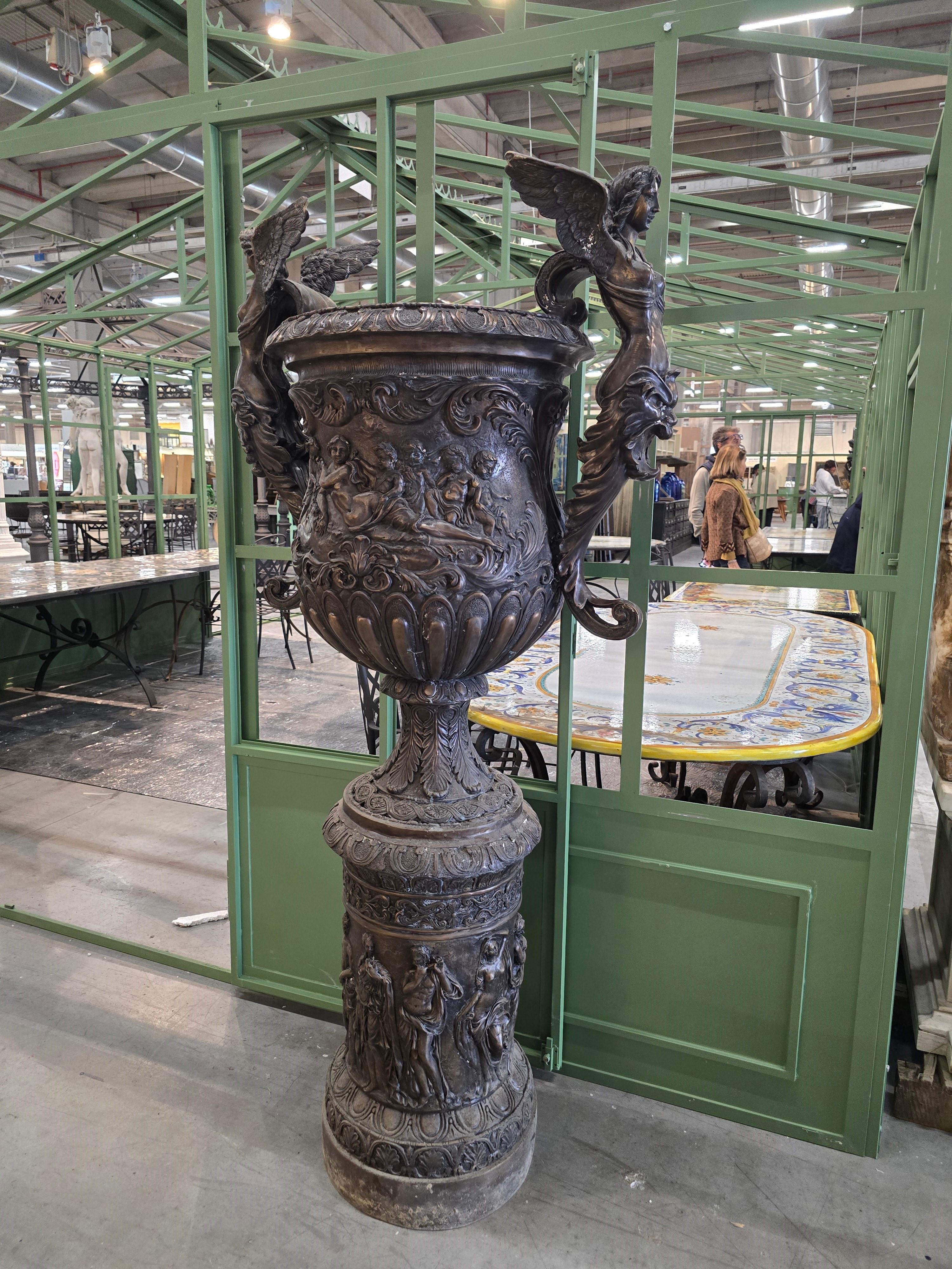 Impressionanti vasi in bronzo di 190 cm, realizzati alla fine del XX secolo in stile barocco. Questi vasi monumentali sono in ottime condizioni e presentano intricati intagli che coprono l'intera superficie. Ogni vaso è affiancato da due angeli che