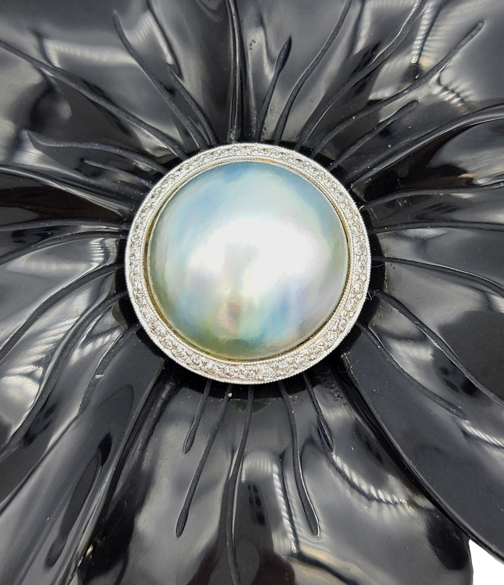 Embrace the opulence of this grand brooch, a botanical masterpiece that seamlessly melds artistry with luxury. The petals, intricately crafted from carved onyx, form an exquisite flower that exudes a timeless elegance. At its heart lies a single