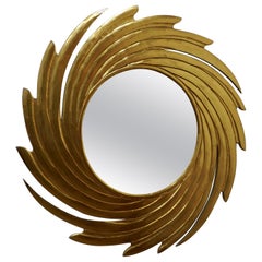 Grand miroir doré sculpté en forme de tourbillon de soleil