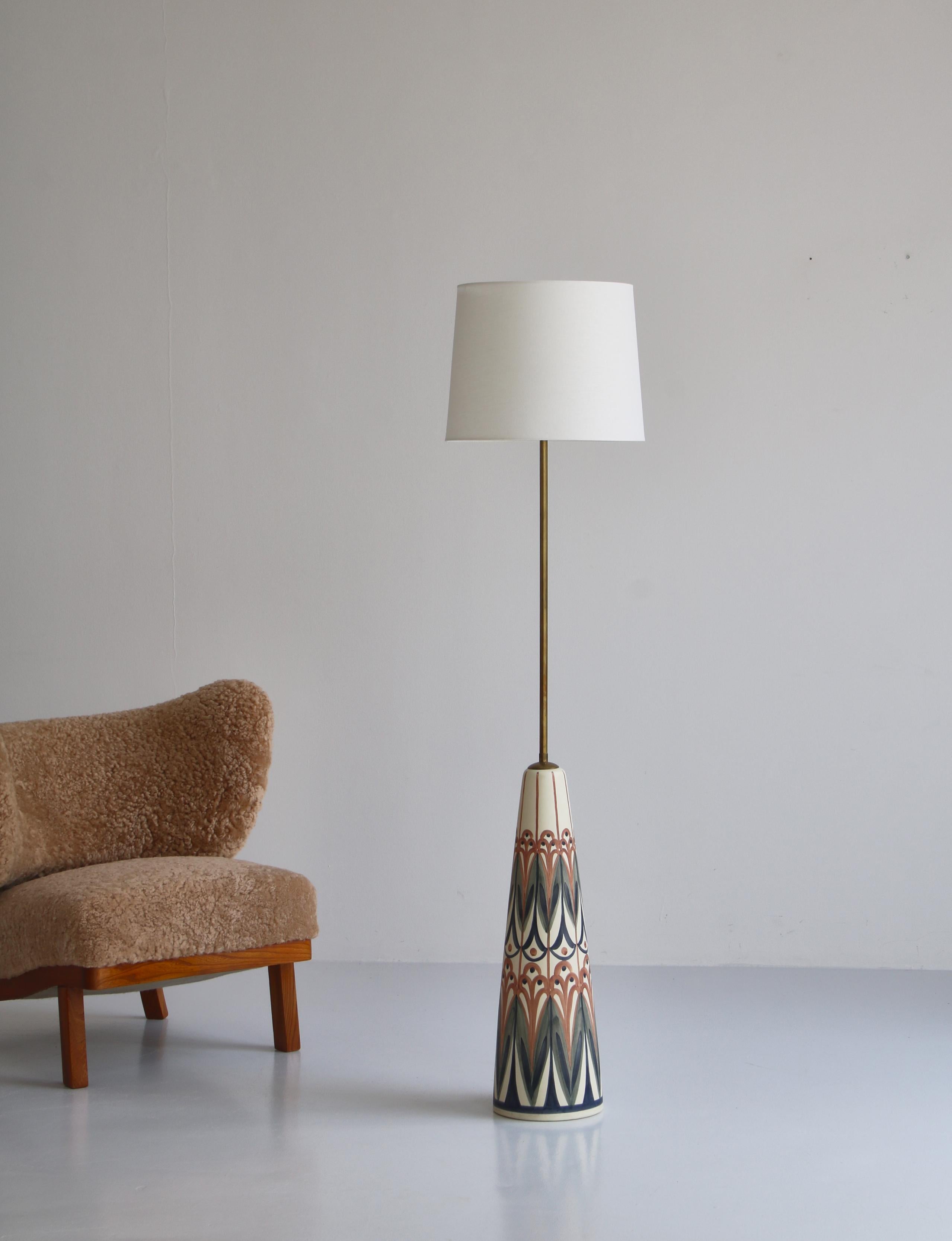 Stunning hand painted floor lamp from the 1960s by Danish artist Rigmor Nielsen at Søholm ceramics workshop, Bornholm. Each of these rare lamps were made by hand and are unique in their decorations. The painted base holds a brass stem with an