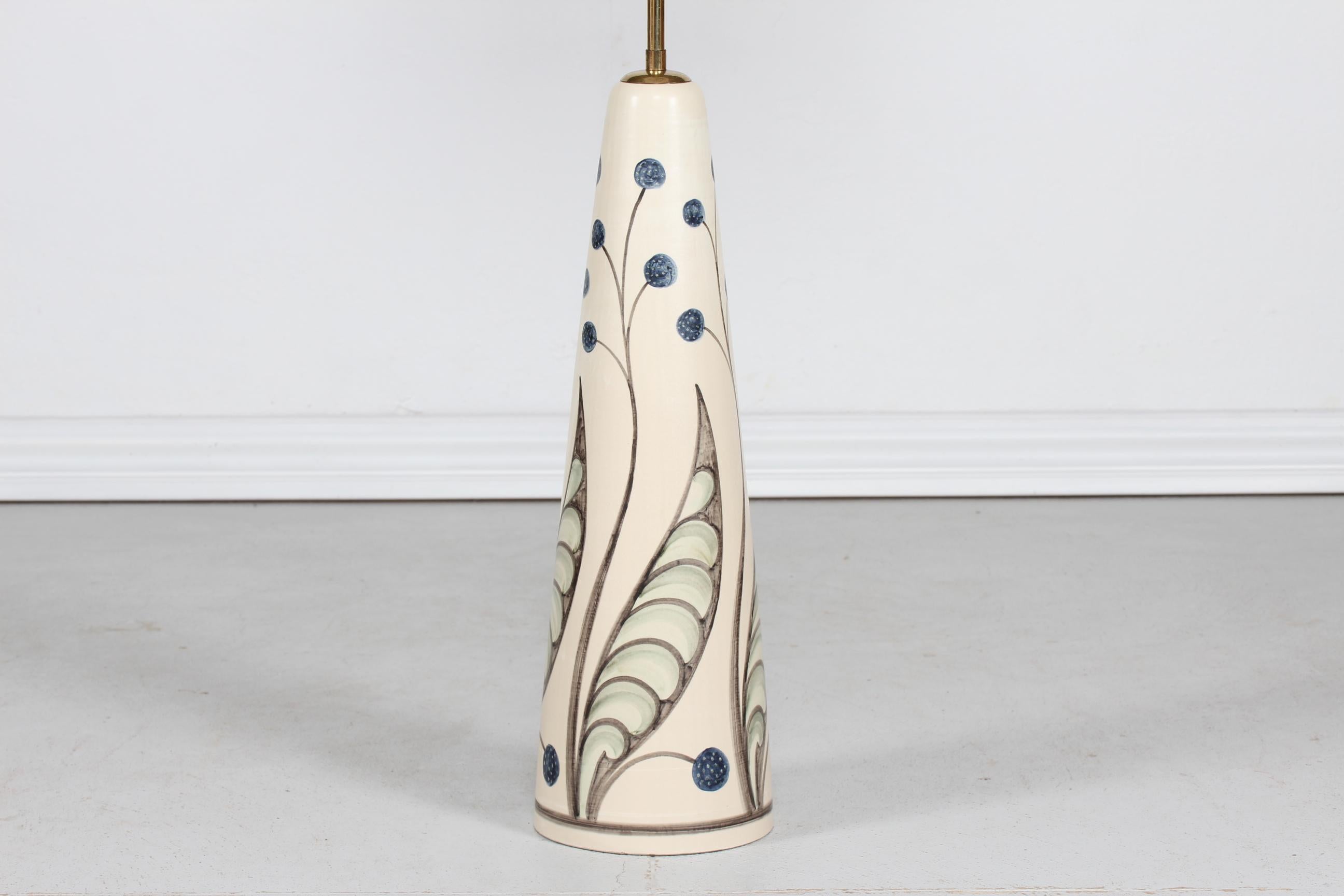 Huge conical hand painted ceramic floor lamp by the Danish artist Rigmor Nielsen for Søholm, Bornholm, Denmark.
The ceramic foot is decorated with a flower motif on an off-white glaze.
It has a brass stem and Included is a new lampshade designed
