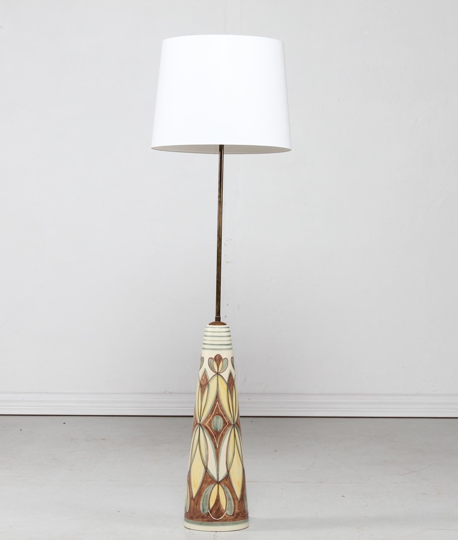 Huge conical hand painted ceramic floor lamp by the Danish artist Rigmor Nielsen for Søholm, Bornholm, Denmark.
The ceramic foot is decorated with a flower motif on an off-white glaze.
It has a brass stem and Included is a new lampshade designed