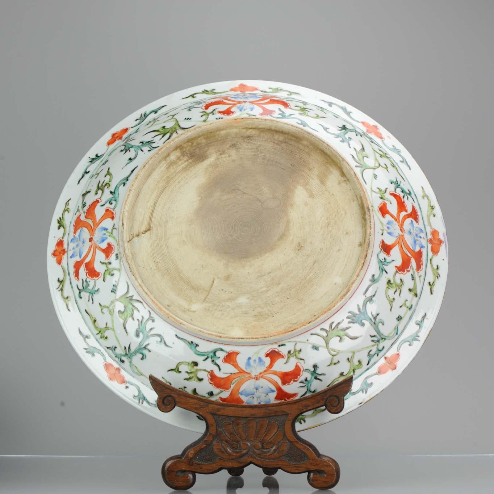 The wide, heavily potted dish is brightly enamelled to the centre with confronting phoenix surrounded with a lotus flower head meander, further encircled with the Eight Buddhist Emblems amongst auspicious clouds, the exterior with further lotus
