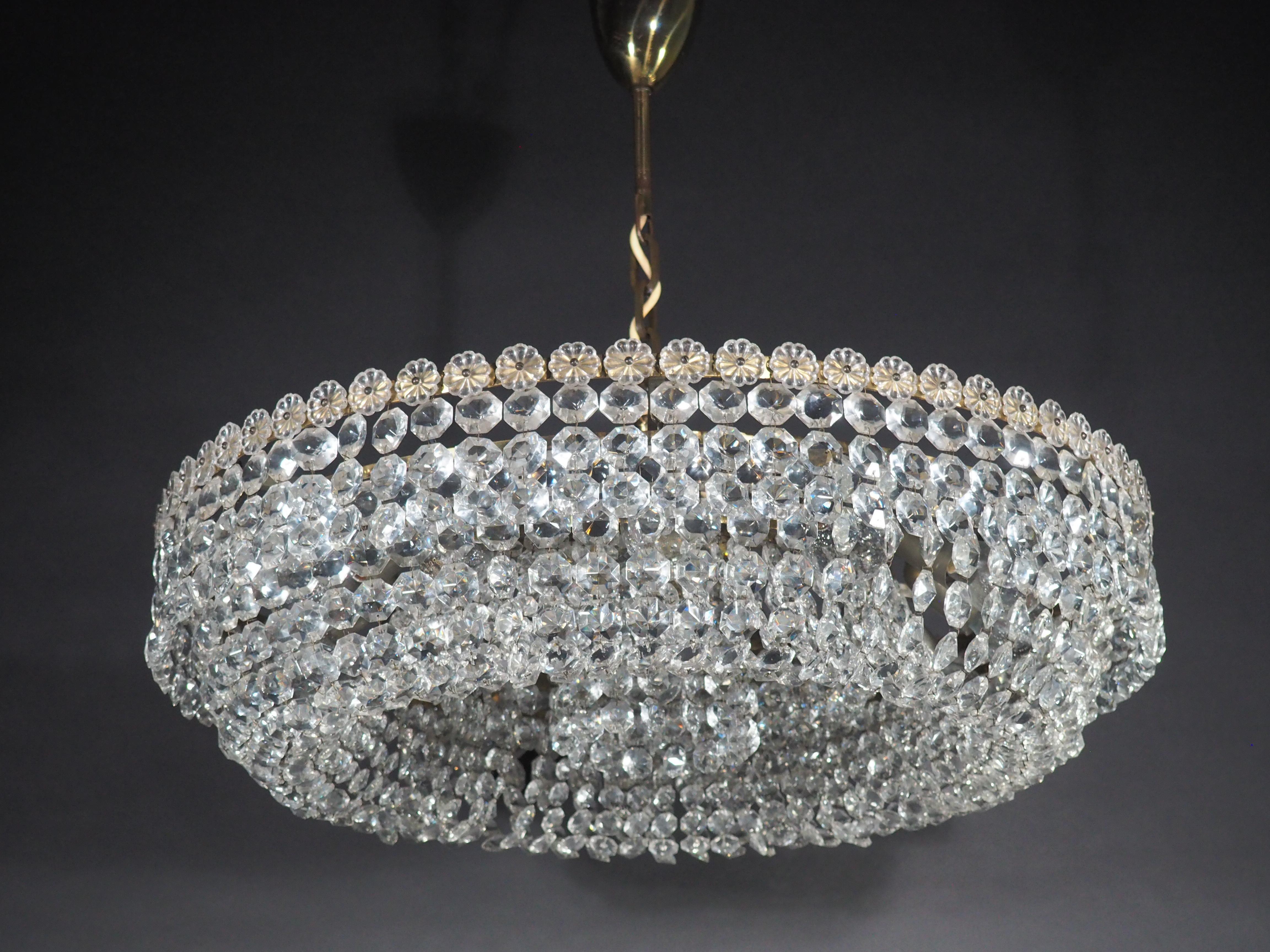 A huge crystal chandelier by Bakalowits or Lobmeyr, Austria, Vienna, circa 1940s.
This beautiful high quality light fixture is handcrafted from brass and hundtrets of crystals.
Socket: 13 x (e27) for standard screw bulbs.

 