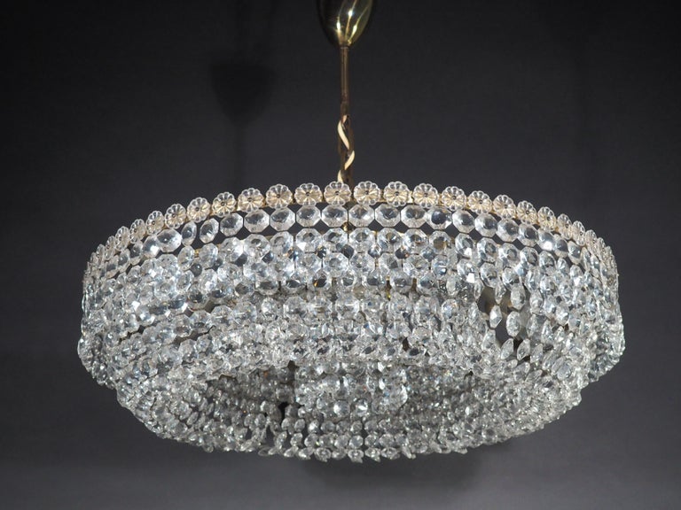 A huge crystal chandelier by Bakalowits or Lobmeyr, Austria, Vienna, circa 1940s.
This beautiful high quality light fixture is handcrafted from brass and hundtrets of crystals.
Socket: 13 x (e27) for standard screw bulbs.

 