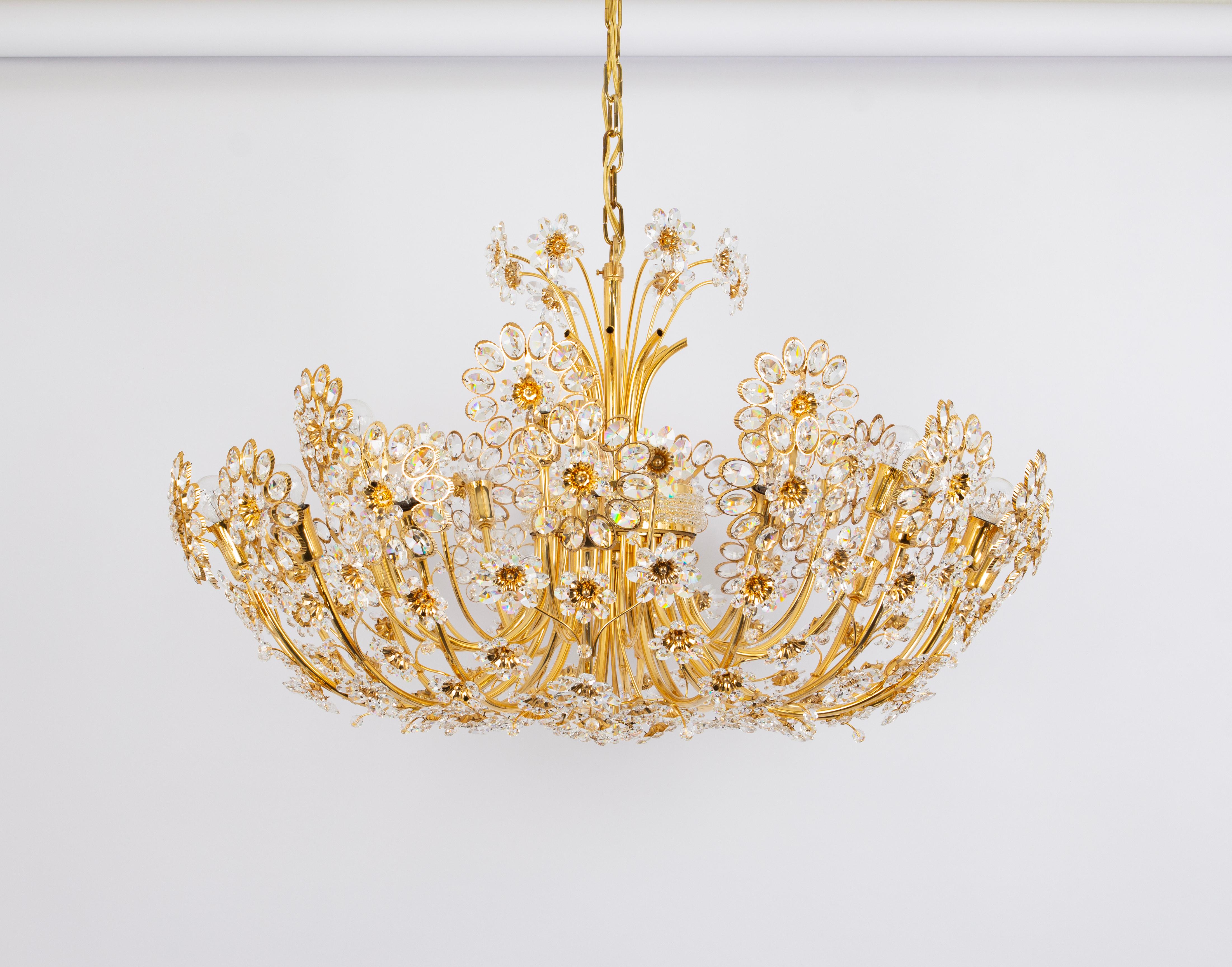 Délicat lustre floral rond en laiton doré, en métal et en verre de cristal, fabriqué par Palwa, Allemagne, vers 1970-1979, documenté dans le catalogue de vente de Palwa. Ce magnifique lustre est composé de nombreux cristaux facettés (Swarovski),