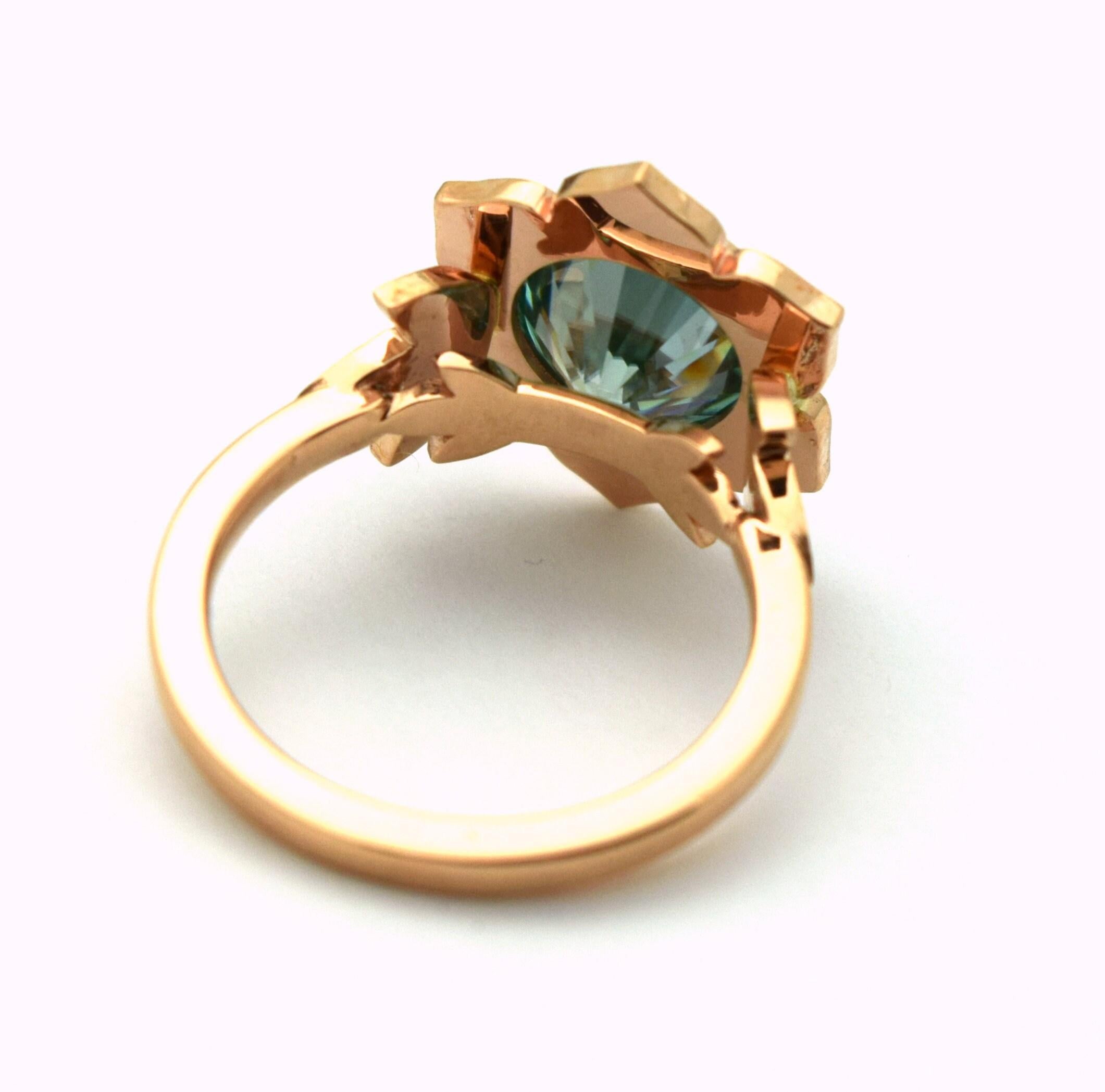 Sunflower ring with a center teal moissanite and natural diamonds in 14KT rose gold, what a beautiful cocktail ring. Daimonds are VS clarity and F color, craftsmanship is amazing!

Certificate of authenticity comes with purchase!

ABOUT US
We are a