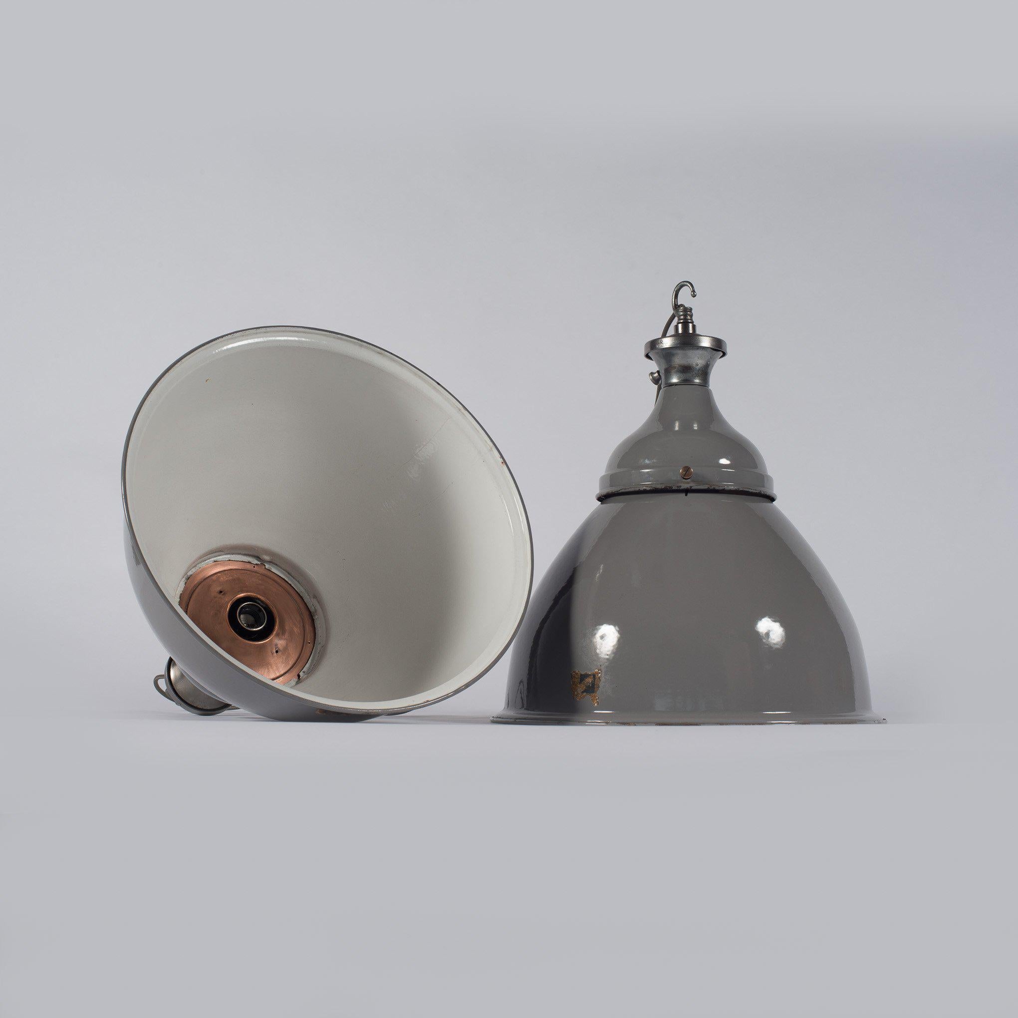 Originali pendenti industriali d'epoca di enormi proporzioni con un design a doppia cupola in due parti del produttore britannico Benjamin Electric Ltd.

Questi pendenti di fabbrica recuperati hanno un paralume a cupola in due parti in smalto