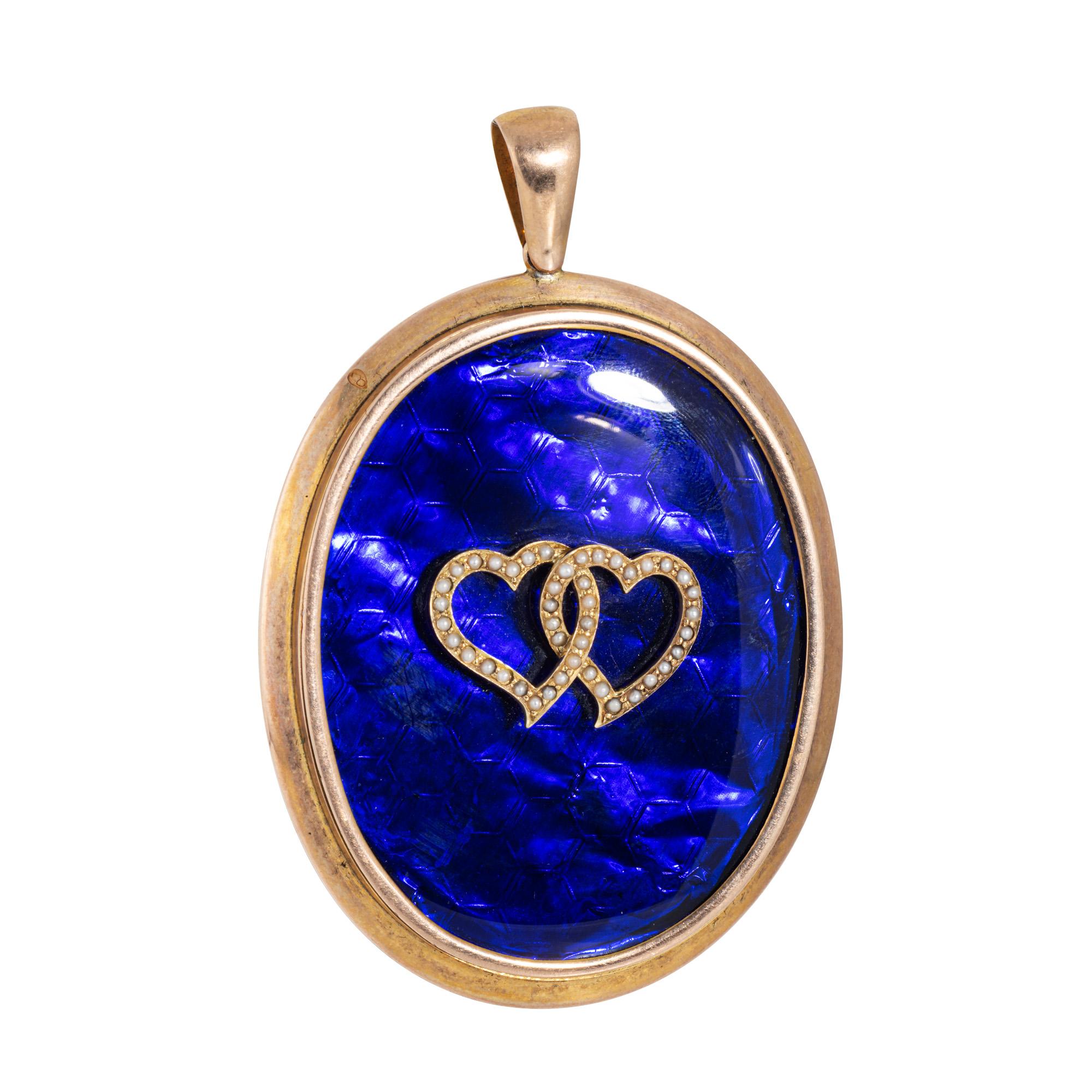 Oversized double heart pendant crafted in 10 karat soft rose gold (circa 1880s to 1900s). 

Small approx. 1mm seed pearls adorn the double hearts. 

The large oval pendant highlights two seed pearl set hearts joined together at the center, set upon