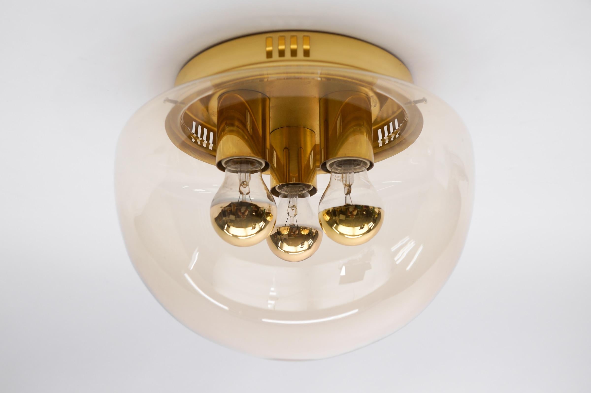 Huge Elegant 3-Light Amber Glass Flush Mount, Germany 1960s

Dimensions
Height: 10.23 in. (26 cm)
Diameter: 12.6 in. (32 cm)

The fixture need 3 x E27 standard bulb with 60W max.

Light bulbs are not included. 
It is possible to install this fixture
