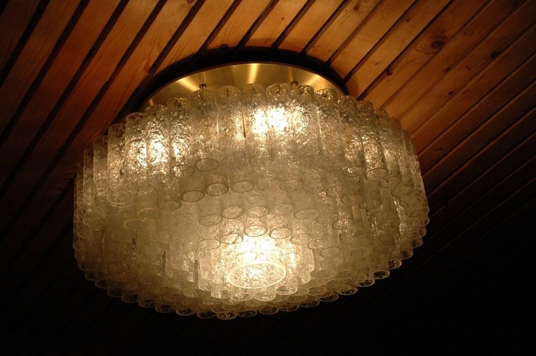 Very large Doria flush mount ceiling light fixture with over a hundred Italian ice glass tubes hanging in 5 tiers from a brass light armature. The chandelier light has one light bulb in the lower center, and six bulbs along the edge of the circle.