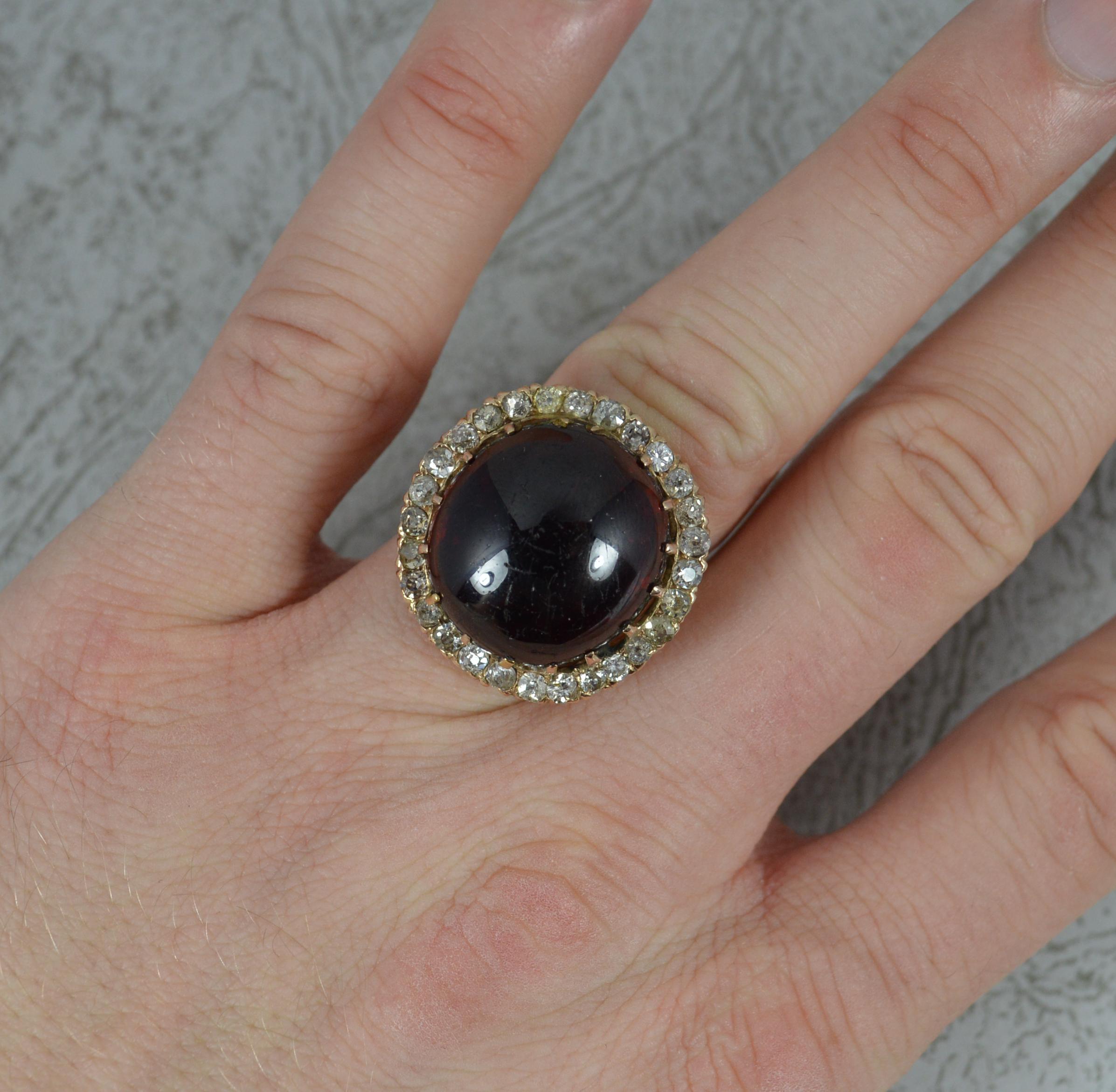 Ein hervorragender Cluster-Ring aus der mittleren bis späten viktorianischen Zeit.
Schaft und Fassung aus massivem 15 Karat Roségold.
Entworfen mit einem riesigen Granat-Cabochon-Stein in einer geschlossenen, folierten Fassung. 17 mm x 18 mm großer