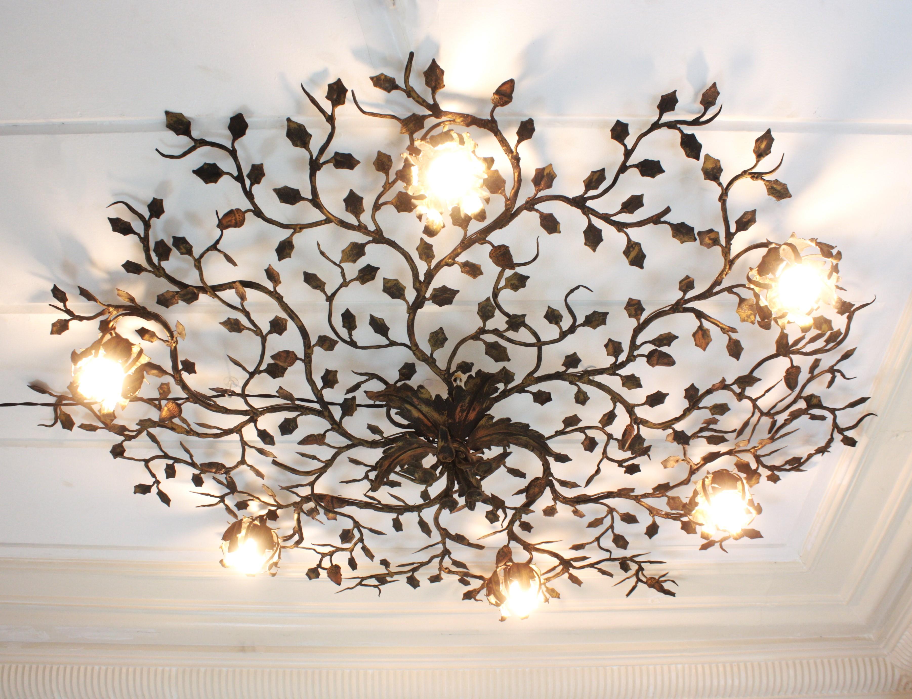 Superbe lampe à fleur de buisson, en fer doré forgé à la main, Espagne, années 1940. 
Une trouvaille rare
Monumental plafonnier de grande taille ( 55,9 in ) en fer doré martelé à la main, avec six lampes à fleurs.
Ce plafonnier a été entièrement