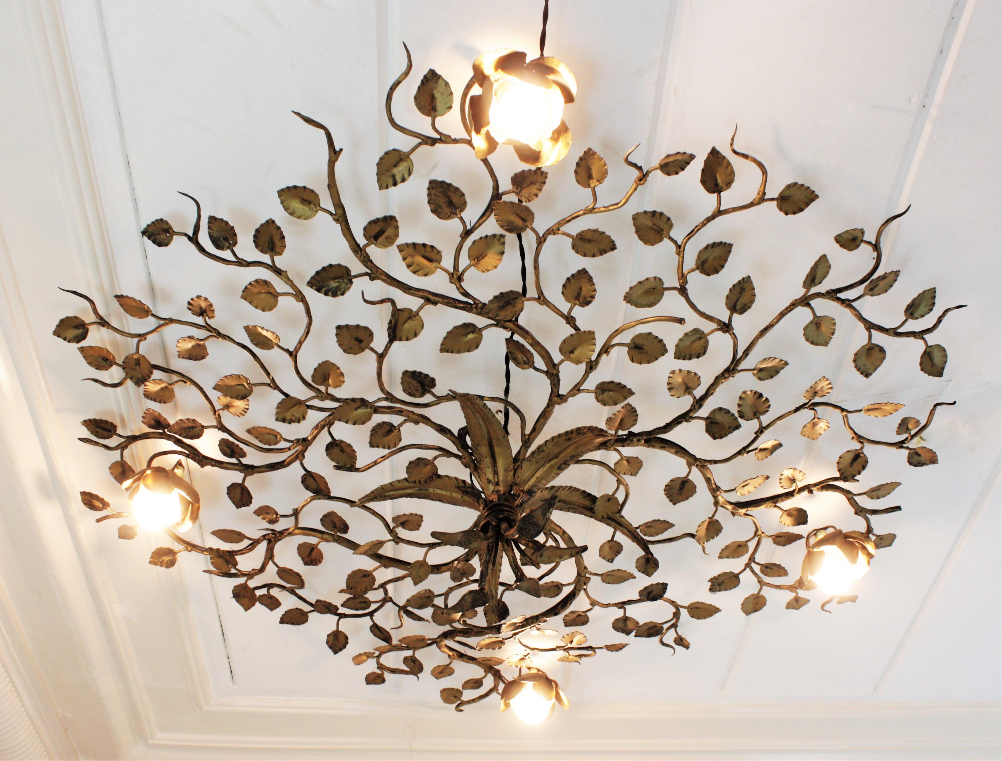 Rosebush tree ornate ceiling flush mount, hand forged gilt iron, Spain, 1960s. 
Monumental large size ( 50,78 in ) hand-hammered gilt iron foliage flower bush ceiling light fixture with four flower lights.
This ceiling light fixture was entirely