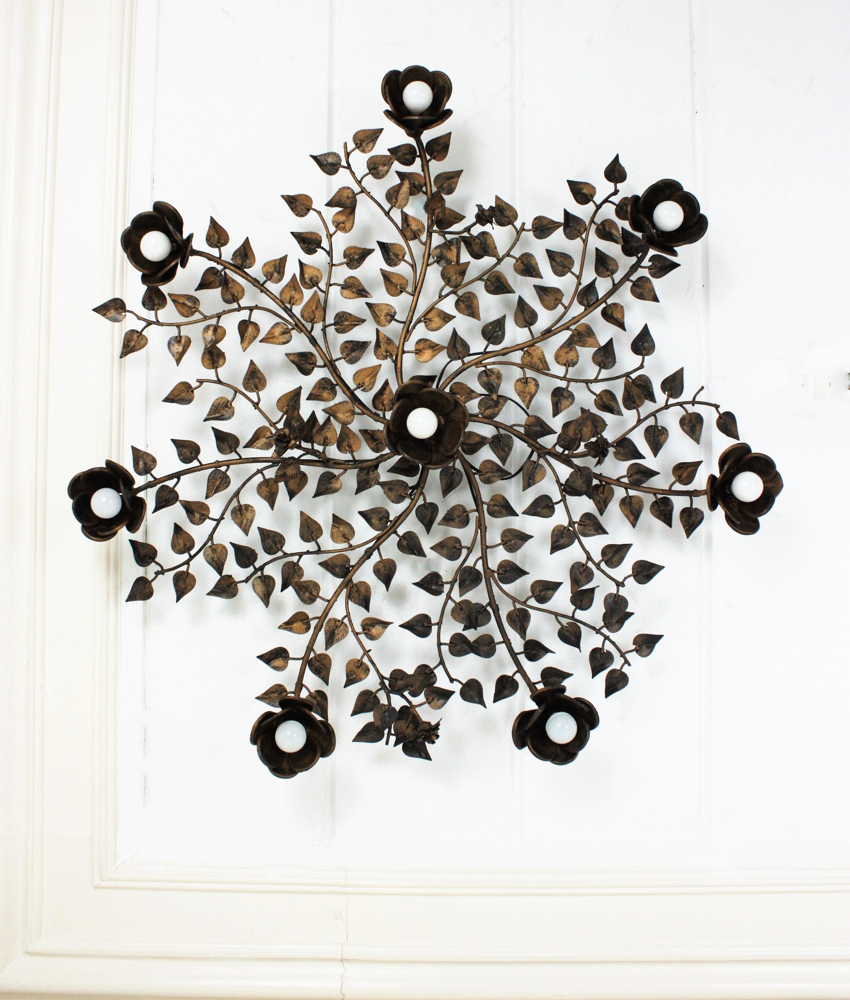 Rosebush tree ornate ceiling flush mount, hand forged gilt iron, Spain, 1960s. 
Monumental large size ( 43,30 in diameter ) hand-hammered gilt iron foliage flower bush ceiling light fixture with eight flower lights.
This ceiling light fixture was