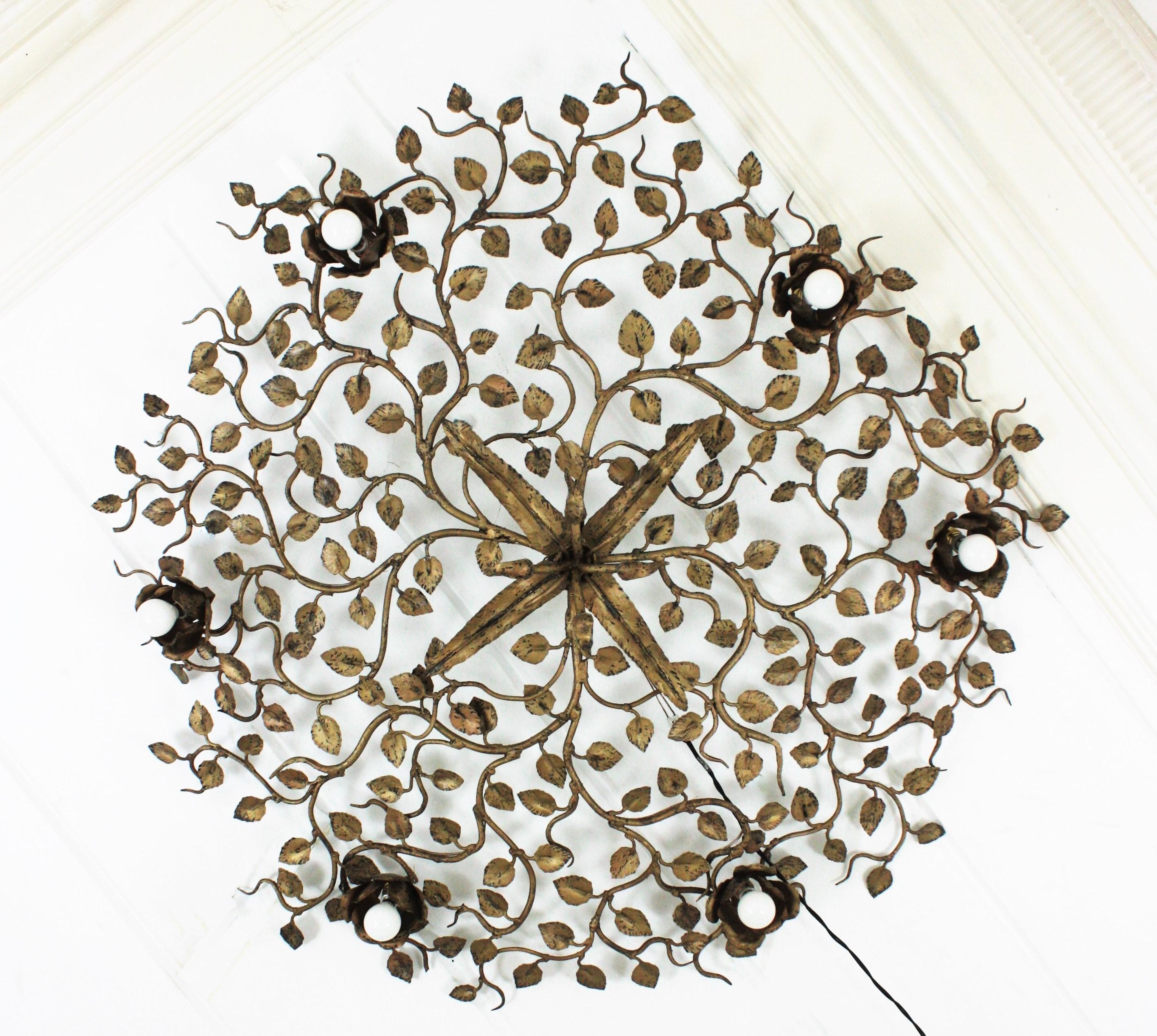 Rosebush tree ornate ceiling flush mount, hand forged gilt iron, Spain, 1950s-1960s. 
Monumental large size ( 47,24 in ) hand-hammered gilt iron foliage flower bush ceiling light fixture with six flower lights.
This ceiling light fixture was