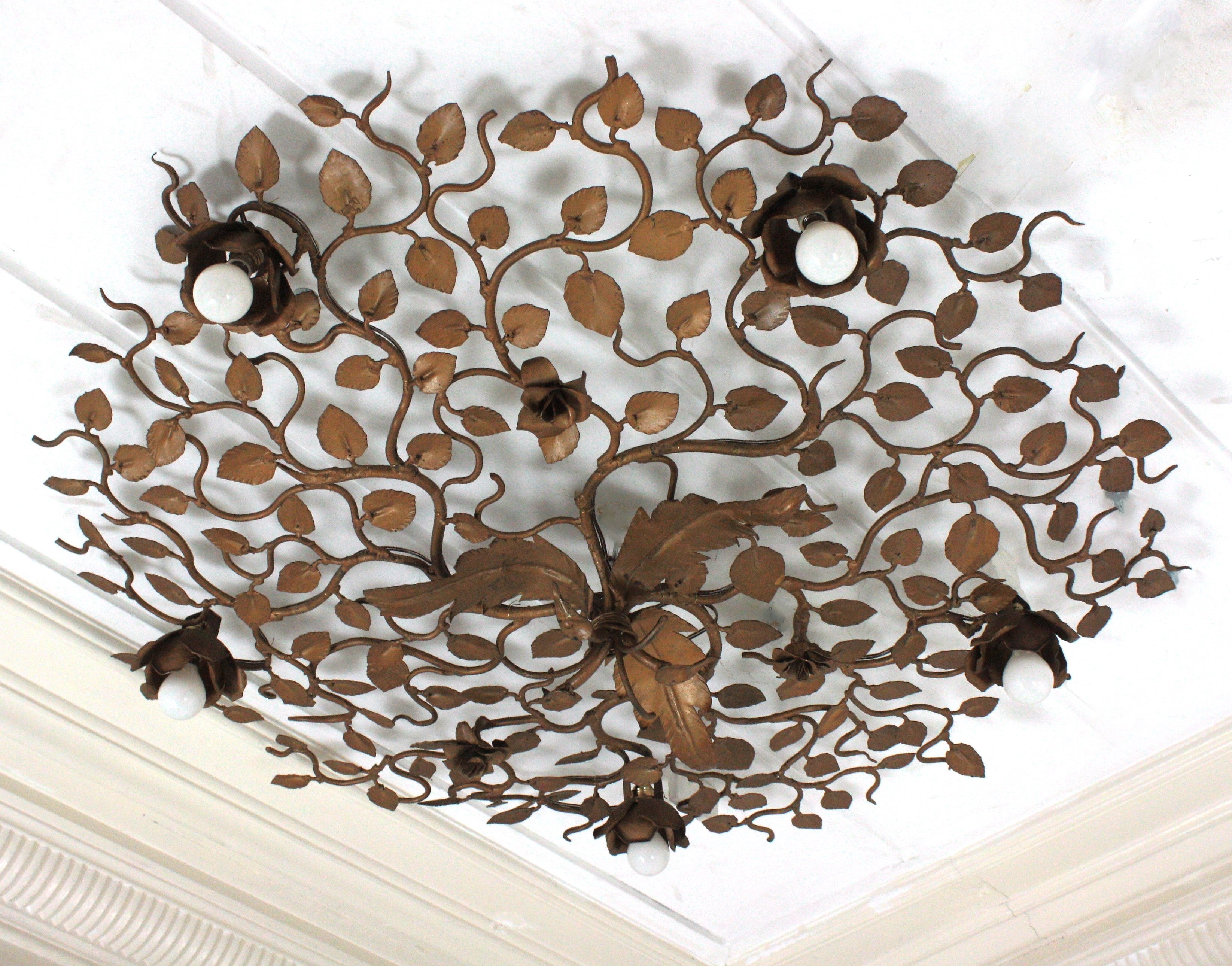 Rosebush tree ornate ceiling flush mount, hand forged gilt iron, Spain, 1950s-1960s. 
Monumental large size ( 42,12) hand-hammered gilt iron foliage flower bush ceiling light fixture with six flower lights.
This ceiling light fixture was entirely