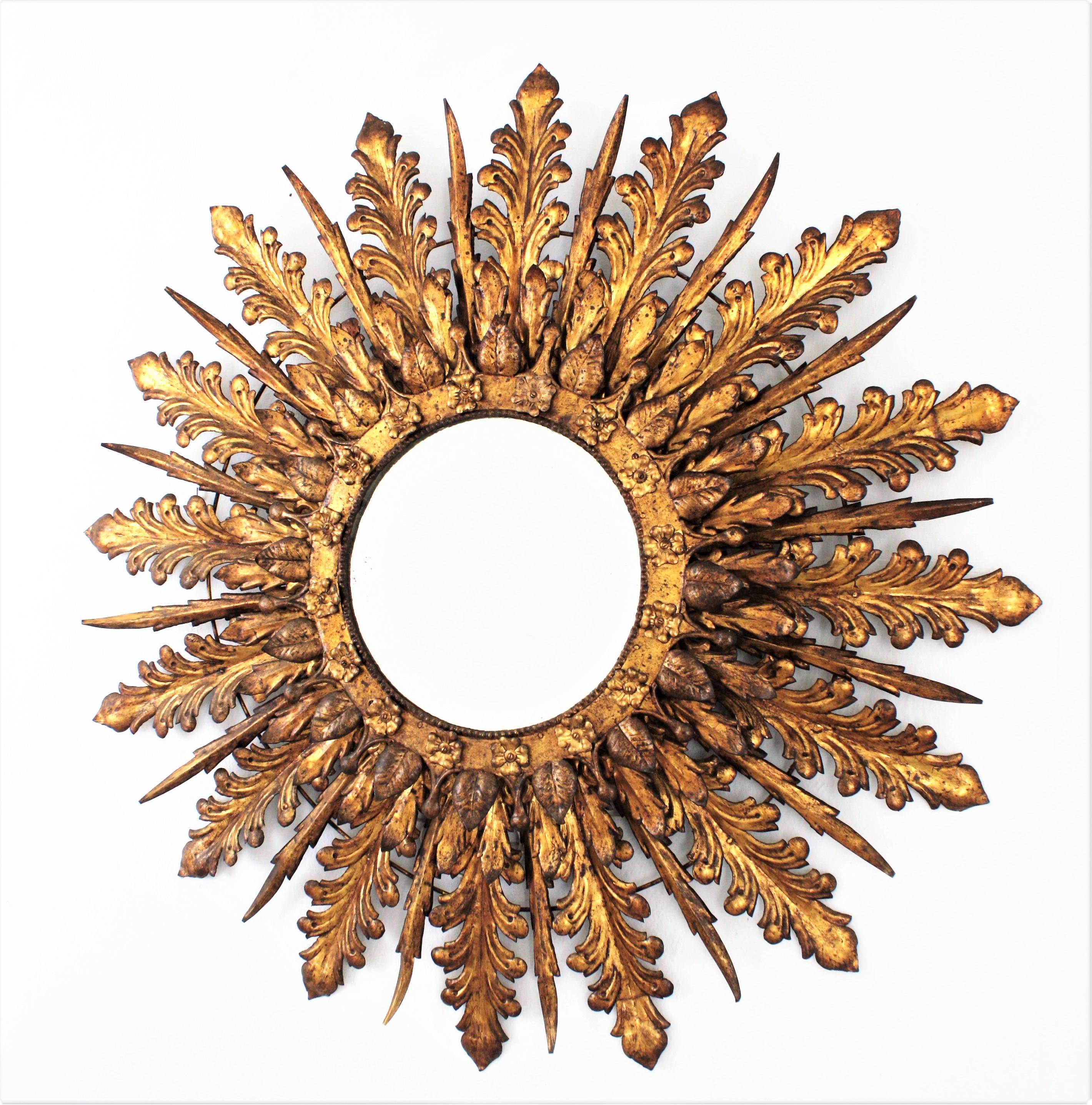 Oversized Baroque style sunburst mirror with triple layered foliage frame. France, 1930s
Massive 100 cm diameter (39.3 in) Baroque style hand-hammered iron leafed sunburst backlit mirror with floral decorations
This outstanding and heavily adorned