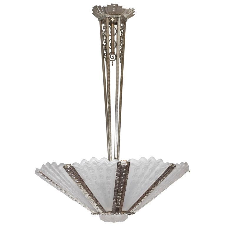 Ce lustre Art déco grandiose et spectaculaire se distingue par ses neuf grands panneaux de verre d'art en forme d'éventail, fortement moulés et dépolis, au sommet ondulé. Ces éléments frappants rayonnent élégamment à partir d'un cadre décoratif en