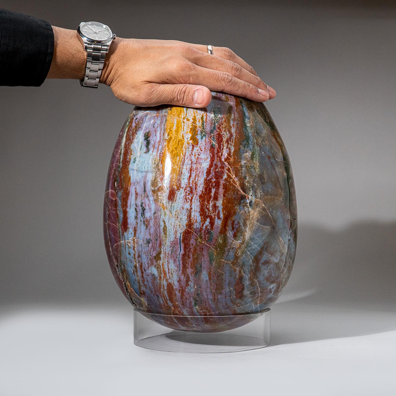 This massive, top-quality polished Ocean Jasper egg from Madagascar, showcases a captivating pattern of blue, red, orange and green hues. This beautiful piece comes with an large acrylic display stand and will be a focal point in any room. Healing