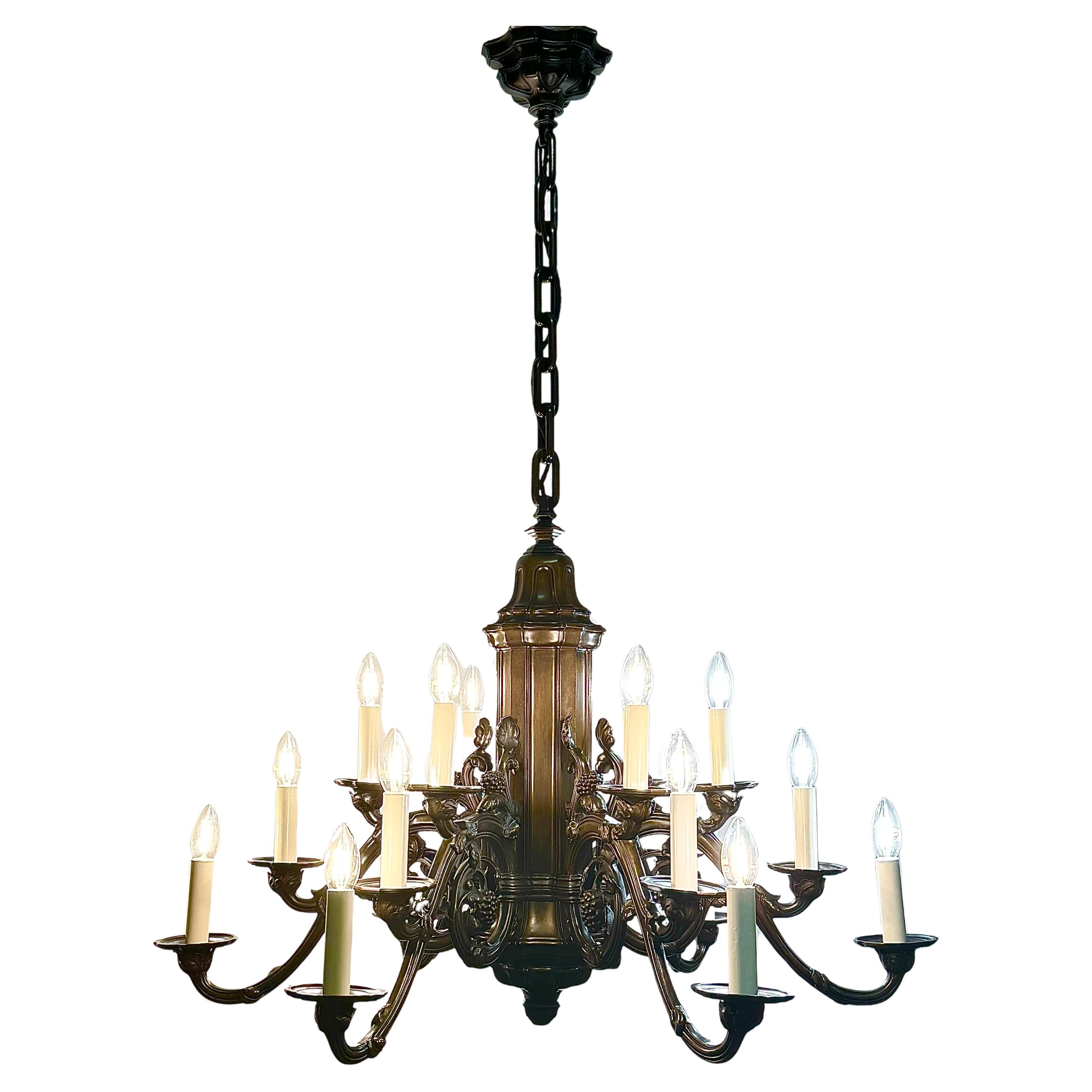 Una enorme lámpara de araña alemana de 18 luces de bronce oscuro, de hacia 1900.
Esta hermosa e impresionante luminaria está hecha de bronce macizo con un motivo de uvas y brazos ricamente decorados sobre una ancha columna.
Cada una de las piezas de