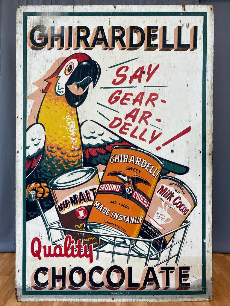 A very rare and full of character 1930s six-foot-tall Ghirardelli Chocolate hand-painted wood advertising sign featuring the company's early and iconic parrot mascot.

Fantastically vibrant and eye-catching outdoor billboard advertising products by