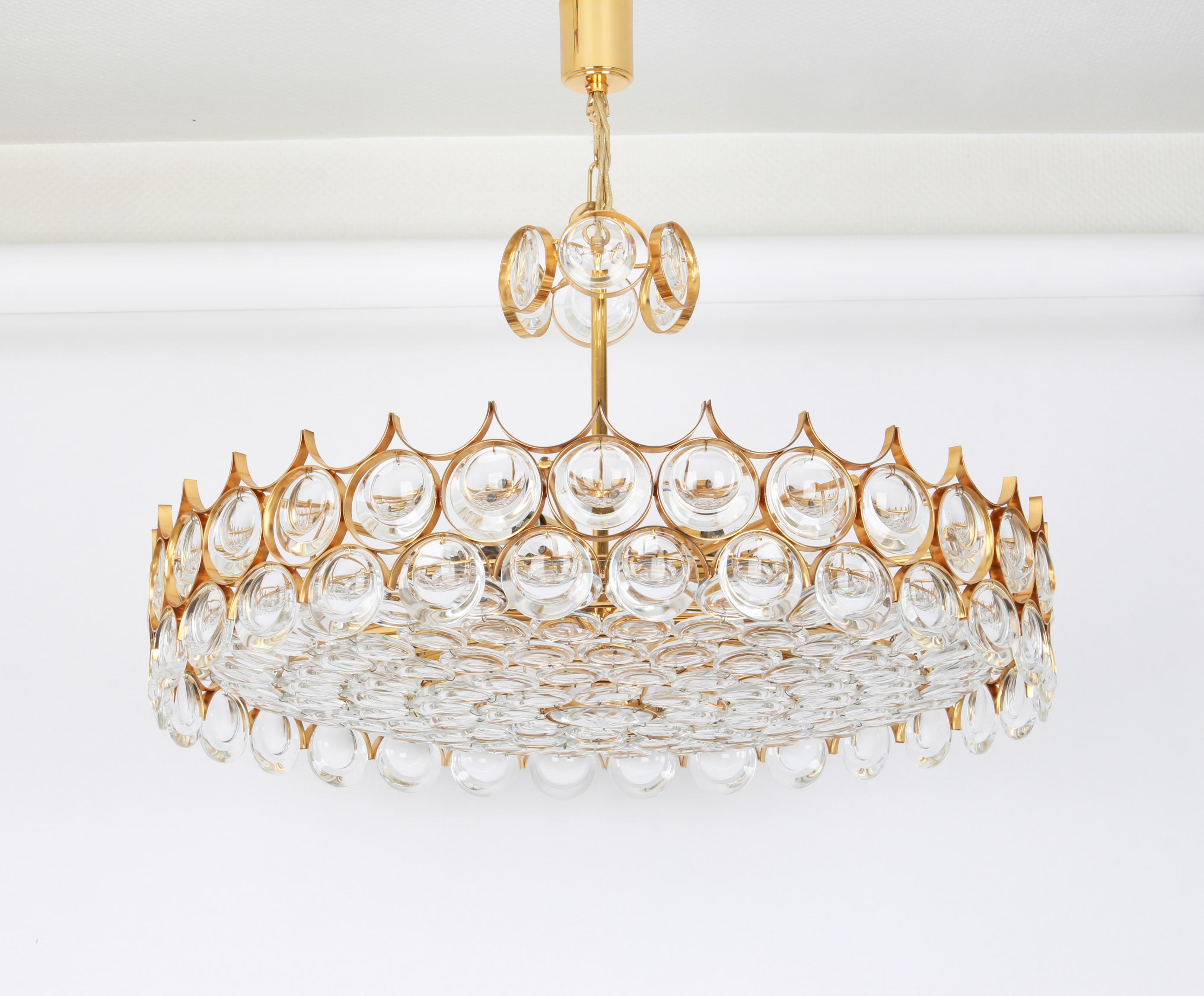 A wonderful and high quality gilded chandelier or pendant light fixture by Palwa -Design Sciolari, Germany, 1970s.
It is made of a 24 carat gold-plated brass frame decorated with individual 
