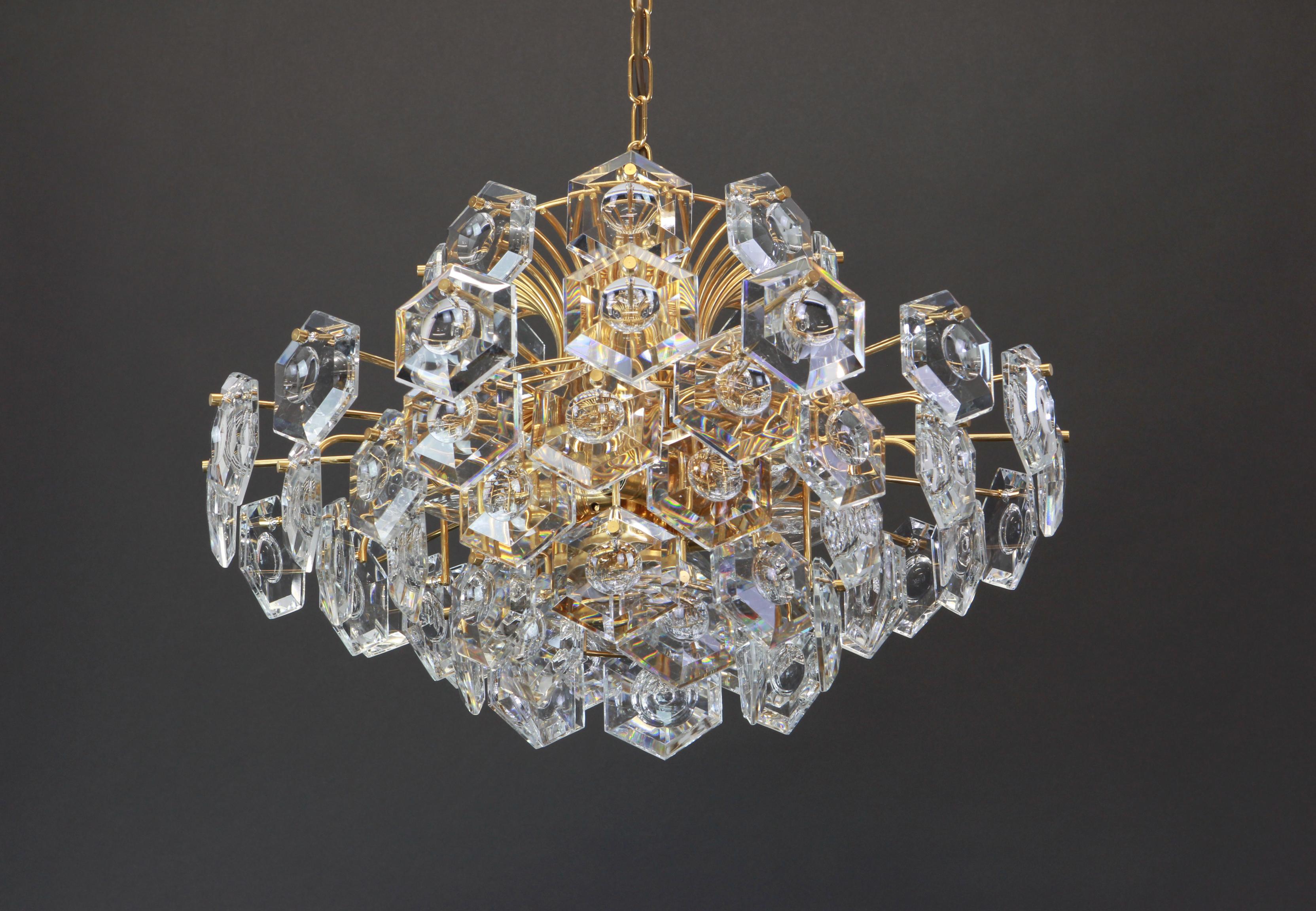 A stunning six-tier chandelier by Kinkeldey, Germany, manufactured in, circa 1960-1969. A handmade and high quality piece. The chandelier features a 24-karat gold-plated eight-tier structure from which 61 quality multifaceted crystals are