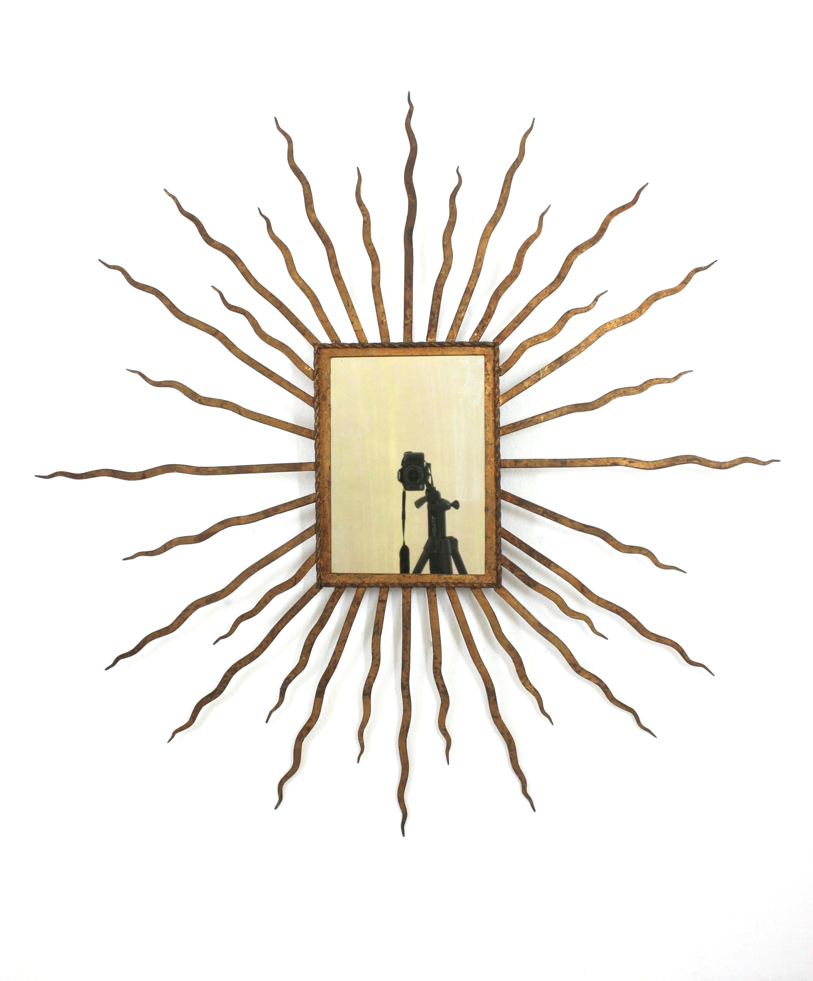 Riesiger Sunburst-Spiegel in der Art von Gilbert Poillerat, vergoldetes Schmiedeeisen. Frankreich, 1940er Jahre.
Seltener Fund aufgrund seiner Größe ( 49 im Durchmesser)
Dieser übergroße Wandspiegel hat ein auffälliges Sunburst-Design mit