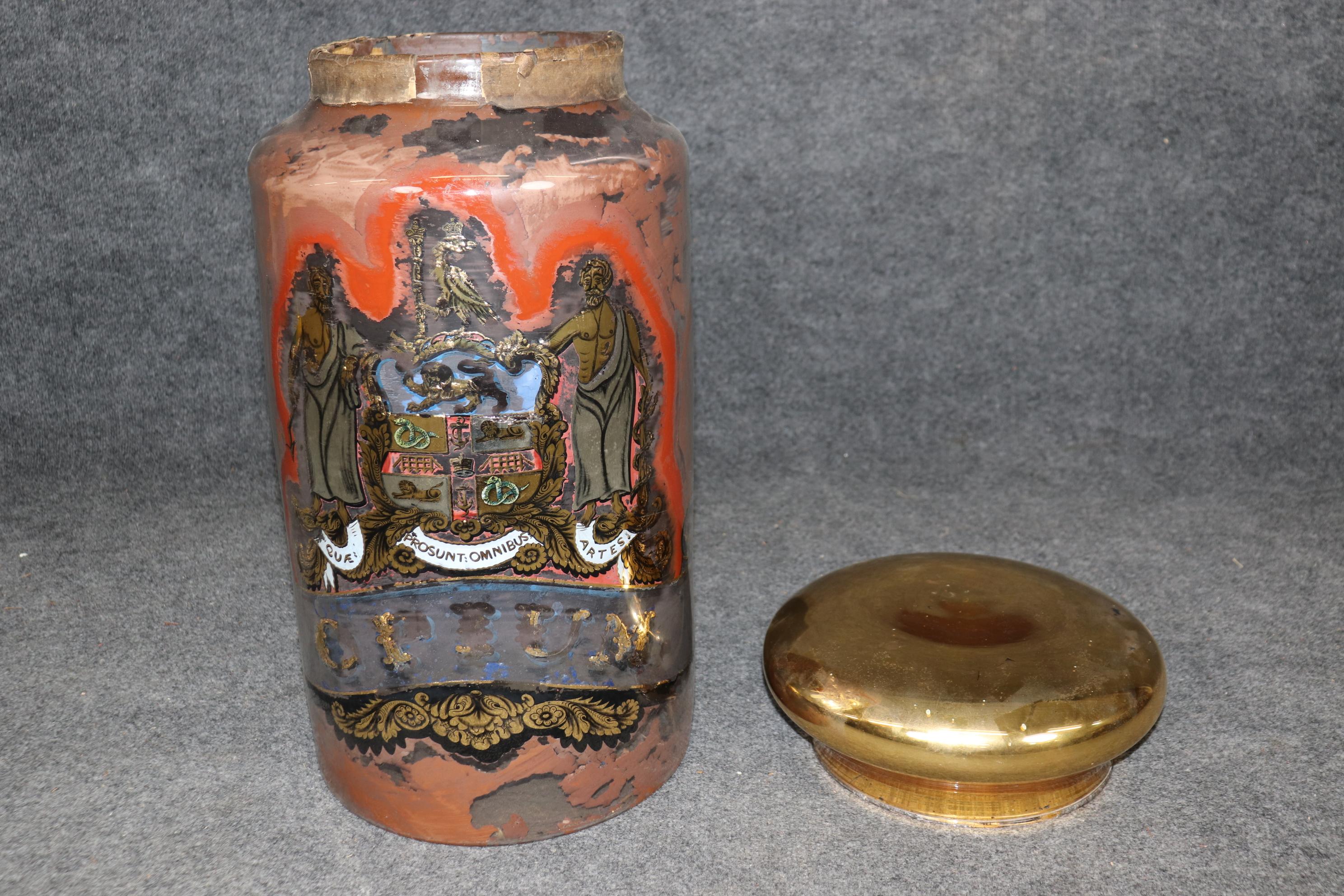 This is a fantastic find! This glass and brass Opium jar is over 2 feet tall and Measures 25.75 tall x 12.25 in diameter. The jar is in good antique condition with signs of losses under the glass, but still retains obvious painted figures, snakes