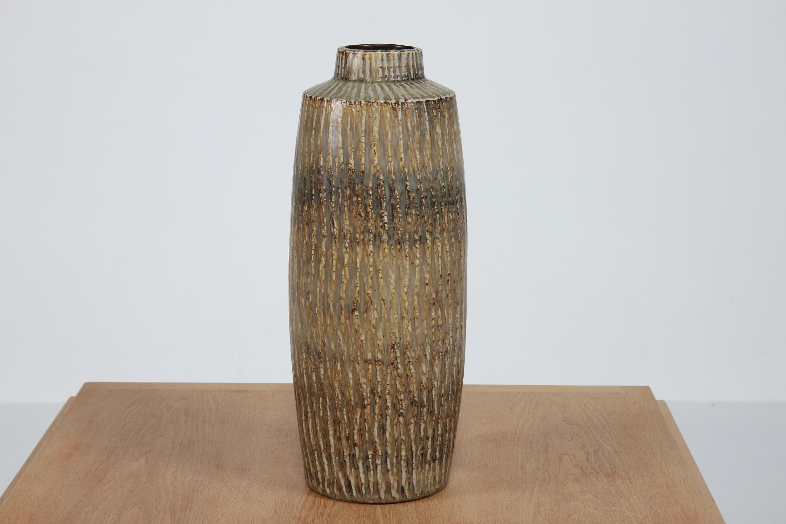 Enorme vaso da terra in gres Rubus disegnato da Gunnar Nylund (1914-1997) negli anni Cinquanta.
Il vaso è decorato con diverse tonalità di smalto marrone e verde.

Firmato a mano con il logo Rörstrand e il monogramma GN per Gunnar