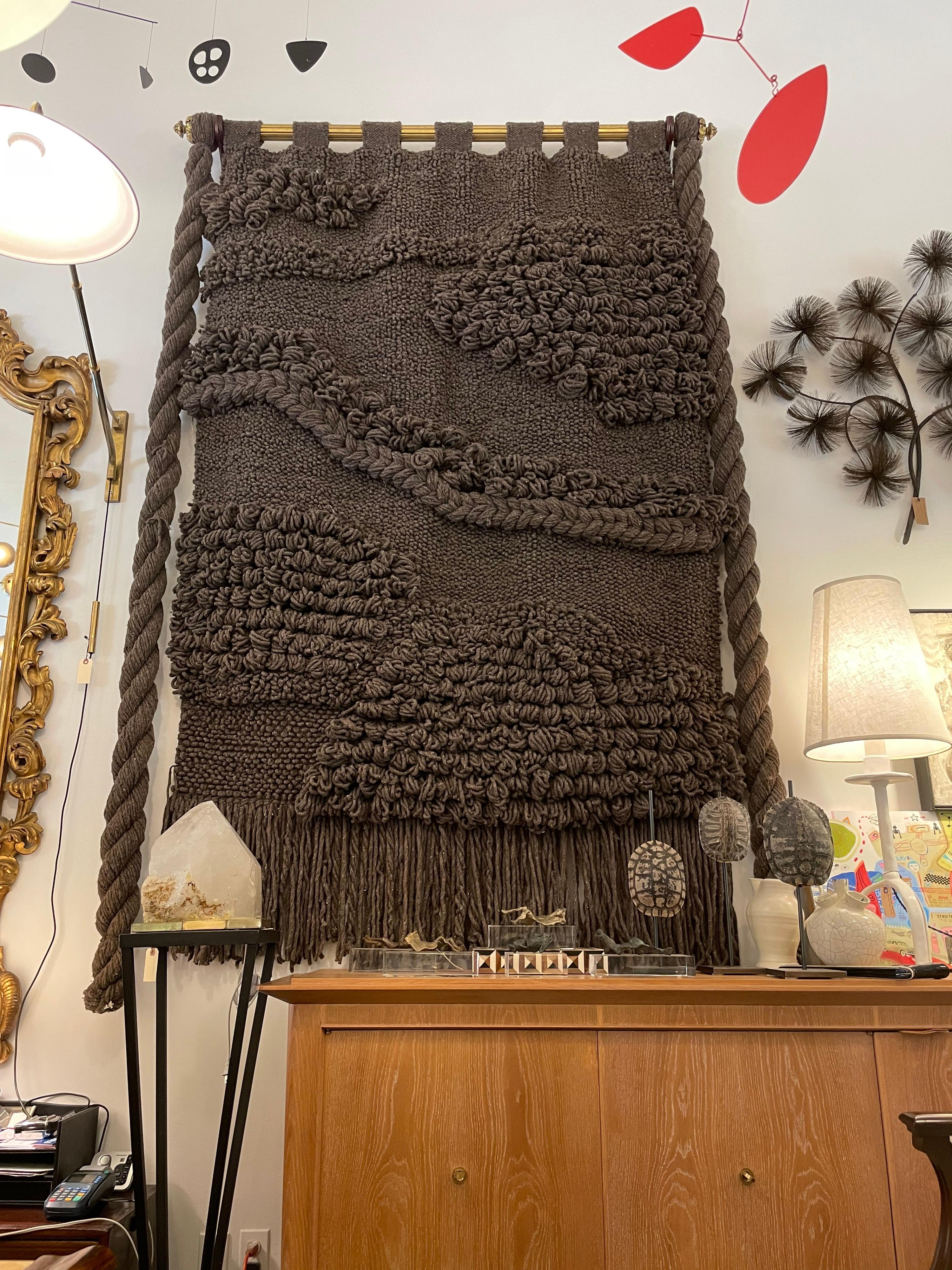 This amazing large wool tapestry with chunky knots and weavings hanging on a custom gilt wood rod is nearly 9 feet long and nearly 6 feet wide. What an important hand made wall art with all natural dyed wood tones.

 